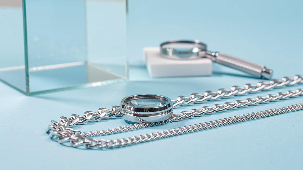 925 silver chains and a ring with a jeweler's loupe