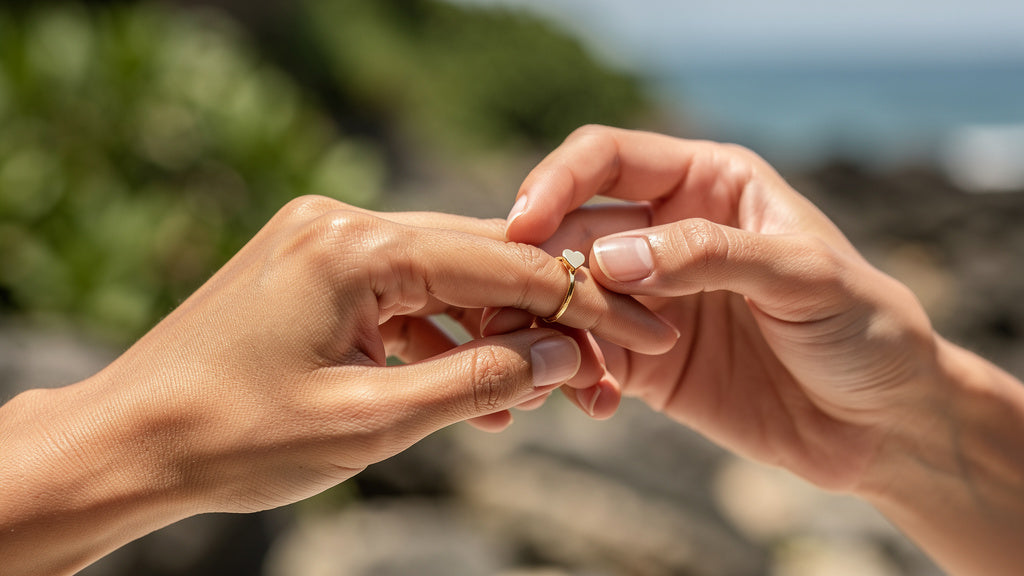 Gold promise ring with a small heart stone being placed on a finger