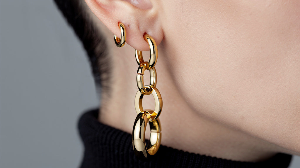 Gold hoop earrings in five sizes lined up from small huggie to large hoop