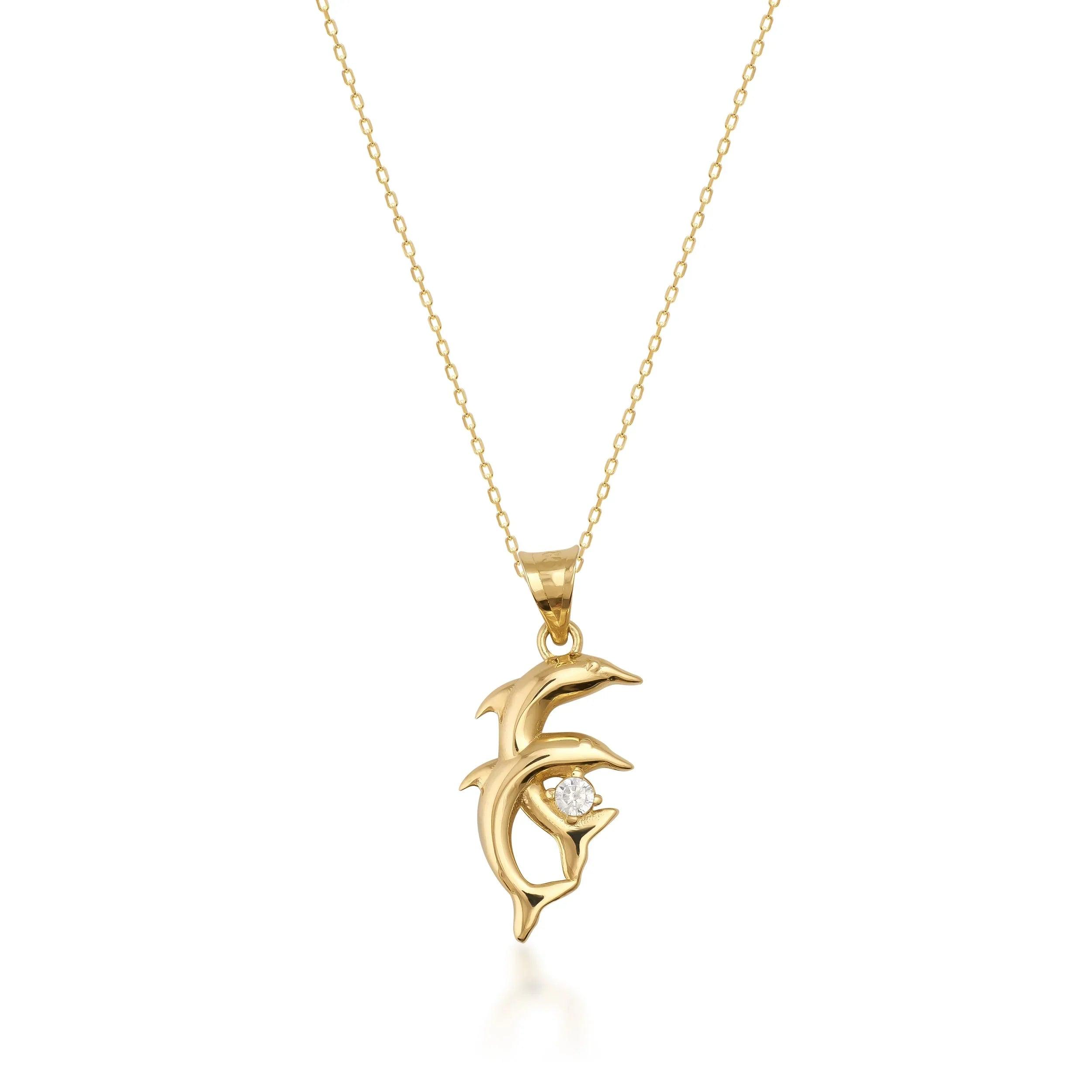 Gold dolphin pendant necklace with diamond accent on a fine gold chain, jewelry product photo