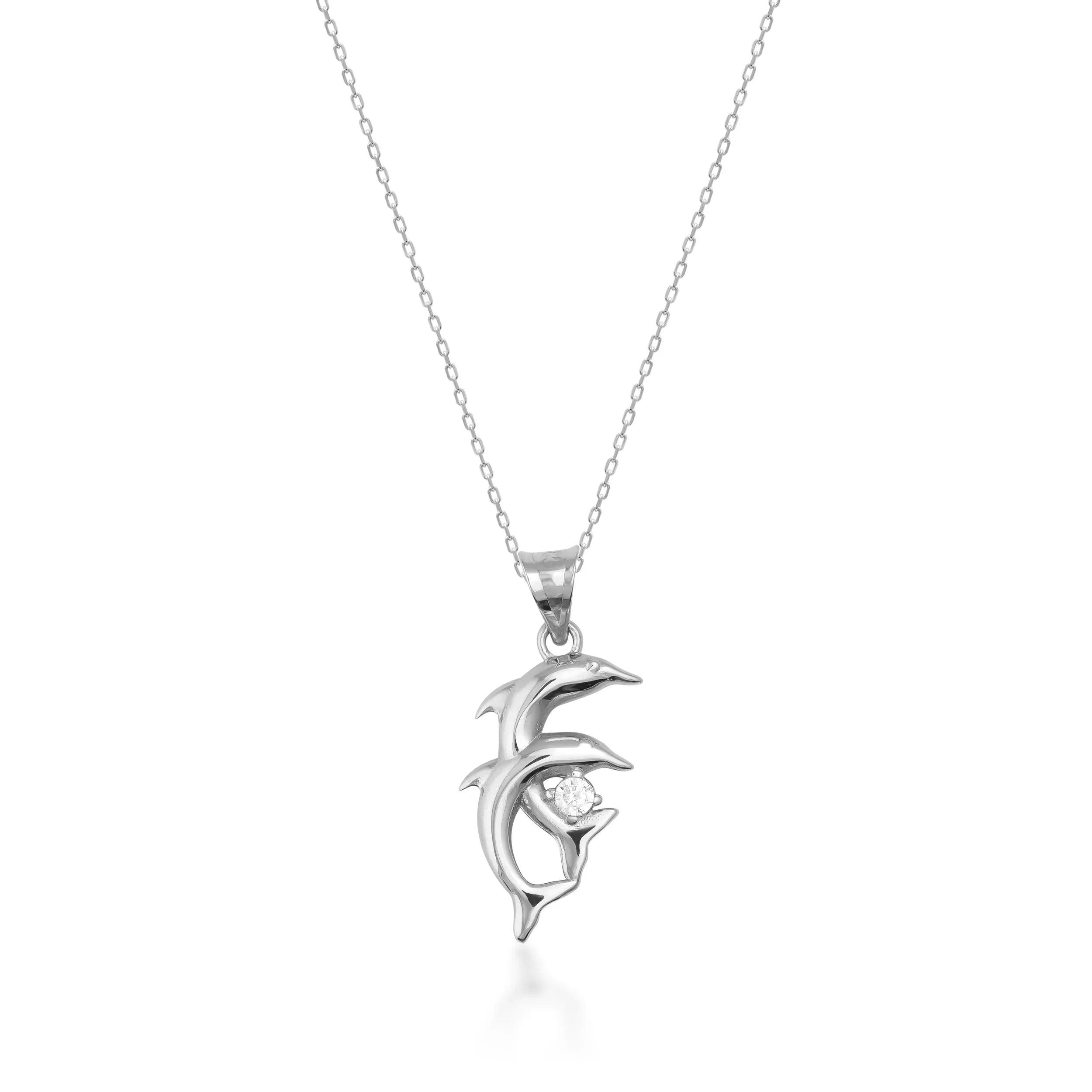Gold dolphin pendant necklace with small gemstone on fine chain, white background