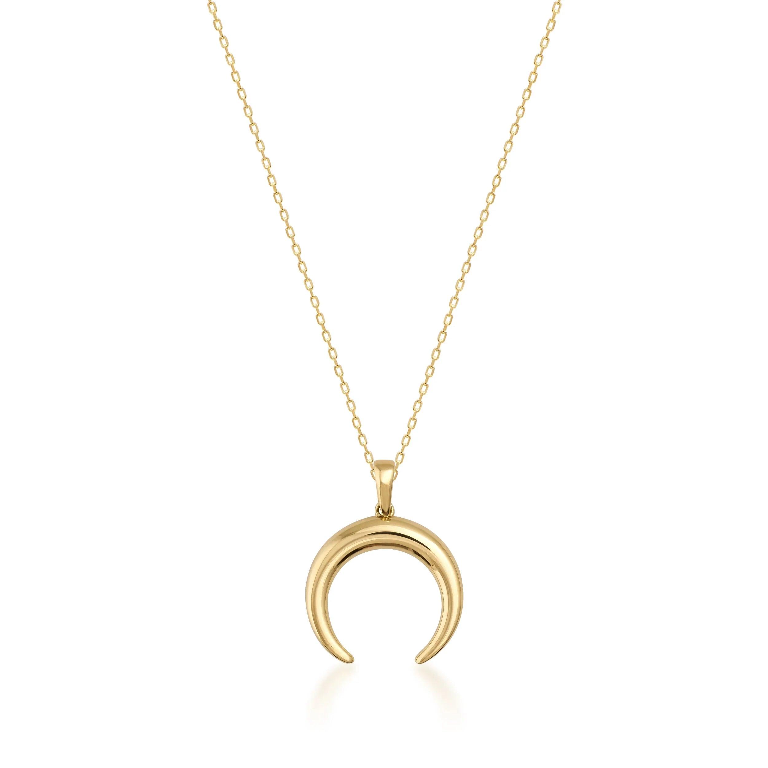 Gold crescent moon pendant necklace with delicate chain on white background