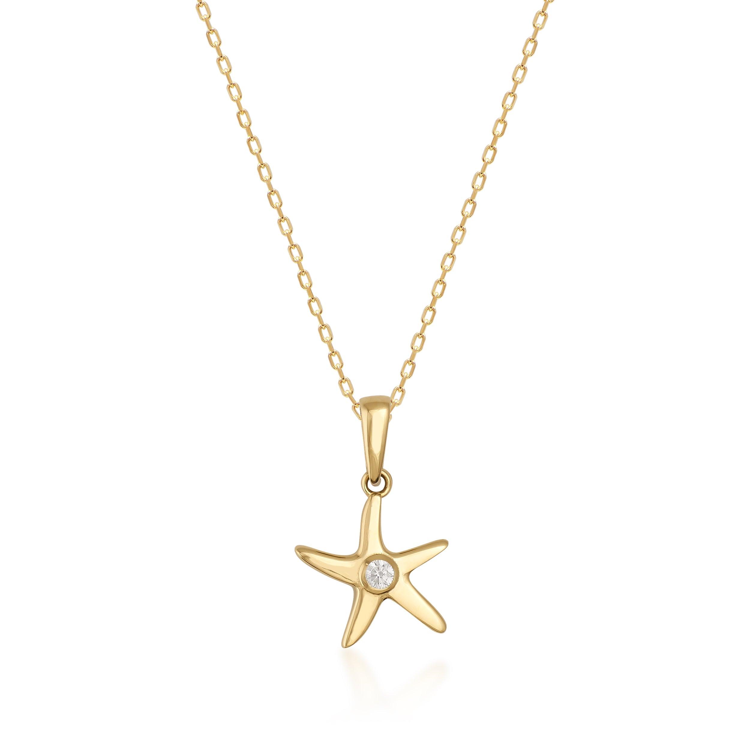 Gold starfish pendant necklace with diamond accent on delicate gold chain, isolated on white