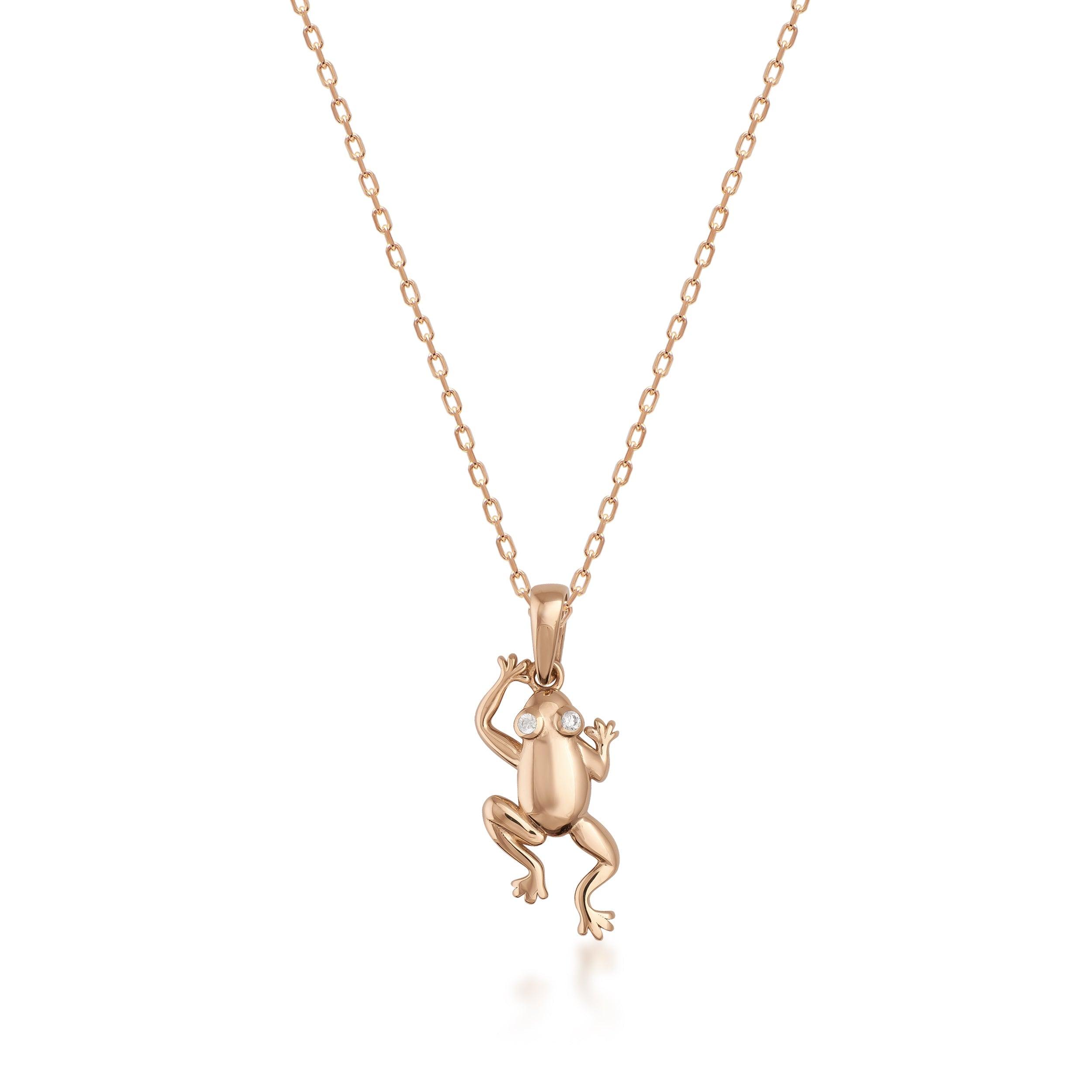 Gold frog pendant necklace with gemstone eyes on fine chain, white background