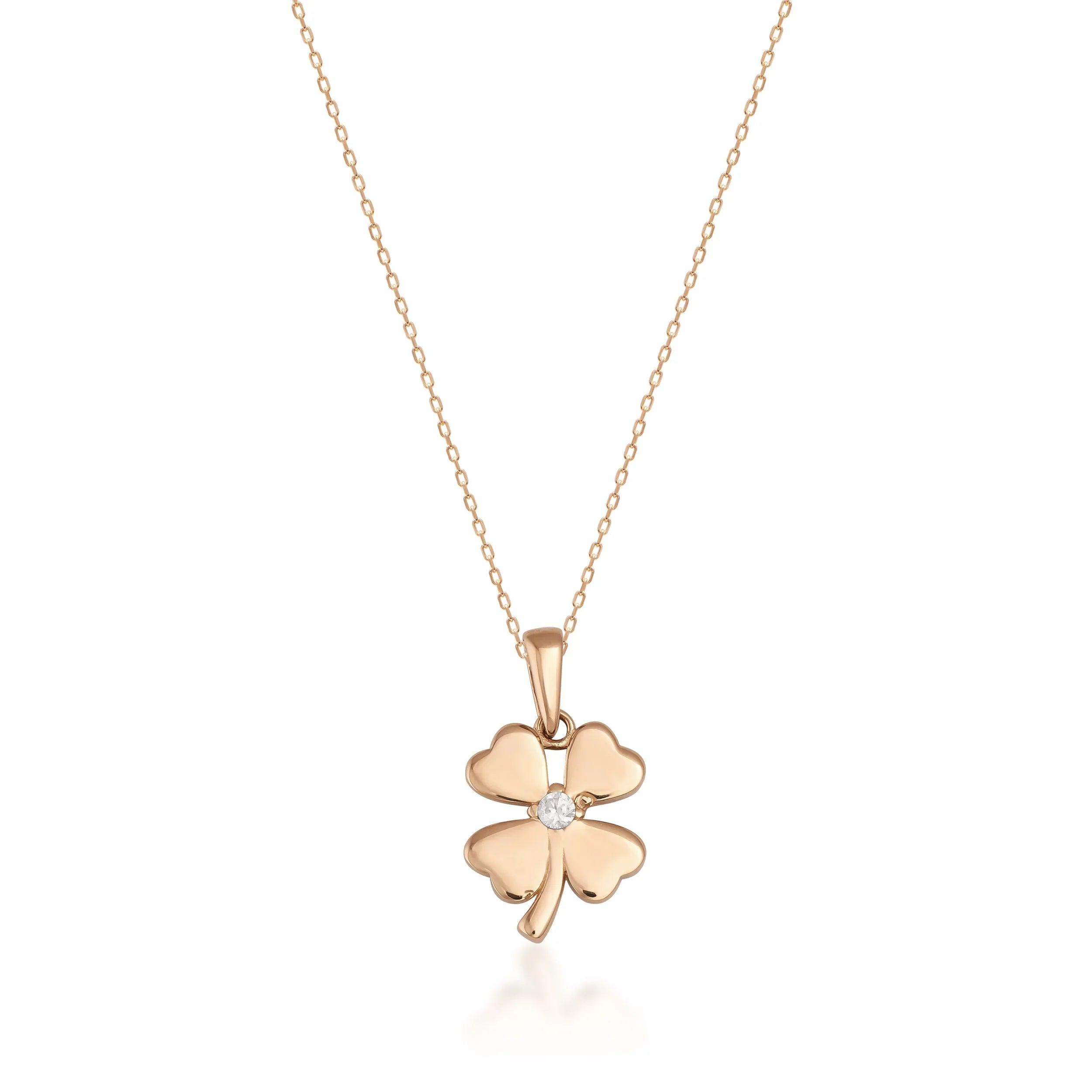 Gold four-leaf clover pendant necklace with central gemstone on fine gold chain