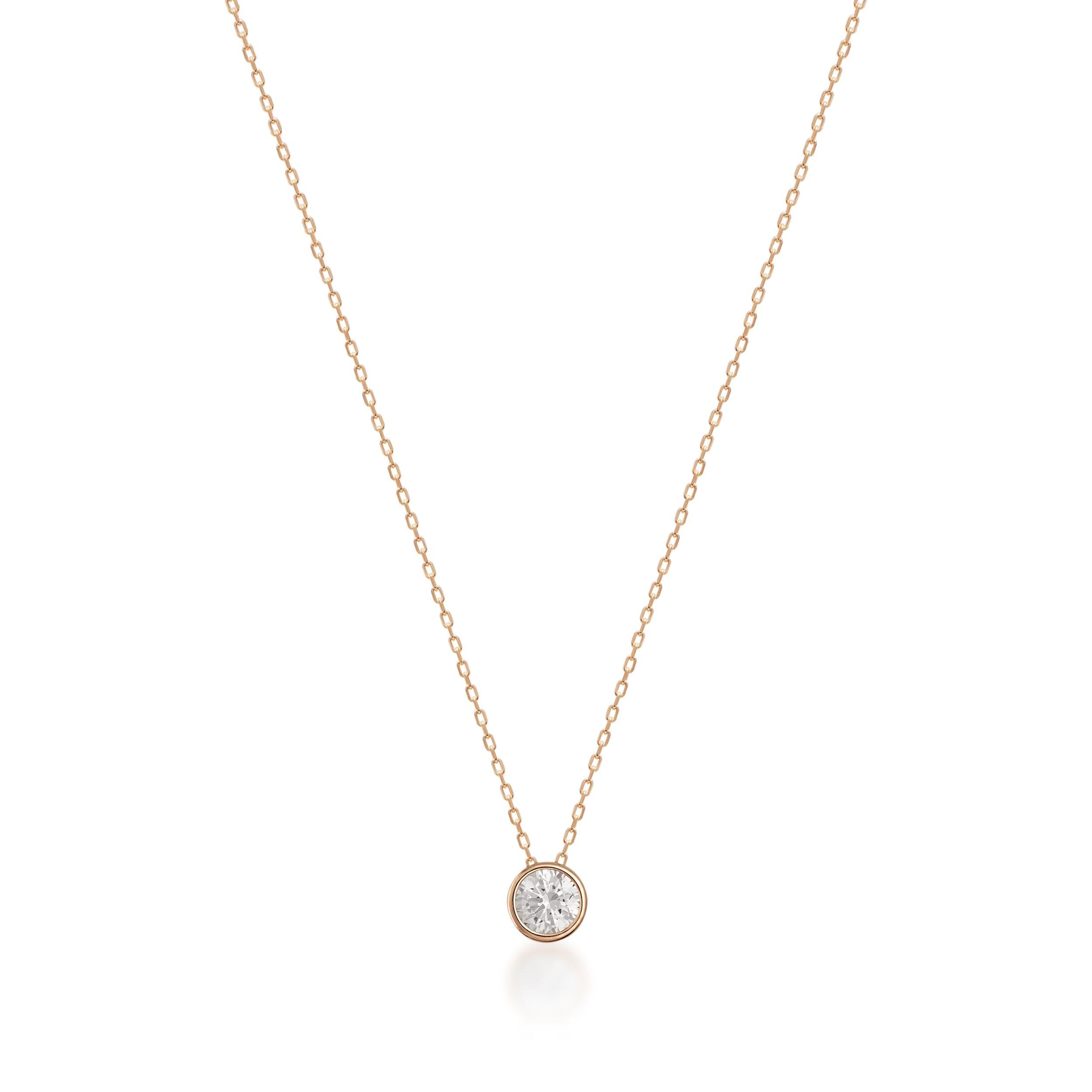 Delicate gold necklace with a bezel-set round diamond solitaire pendant on a fine chain