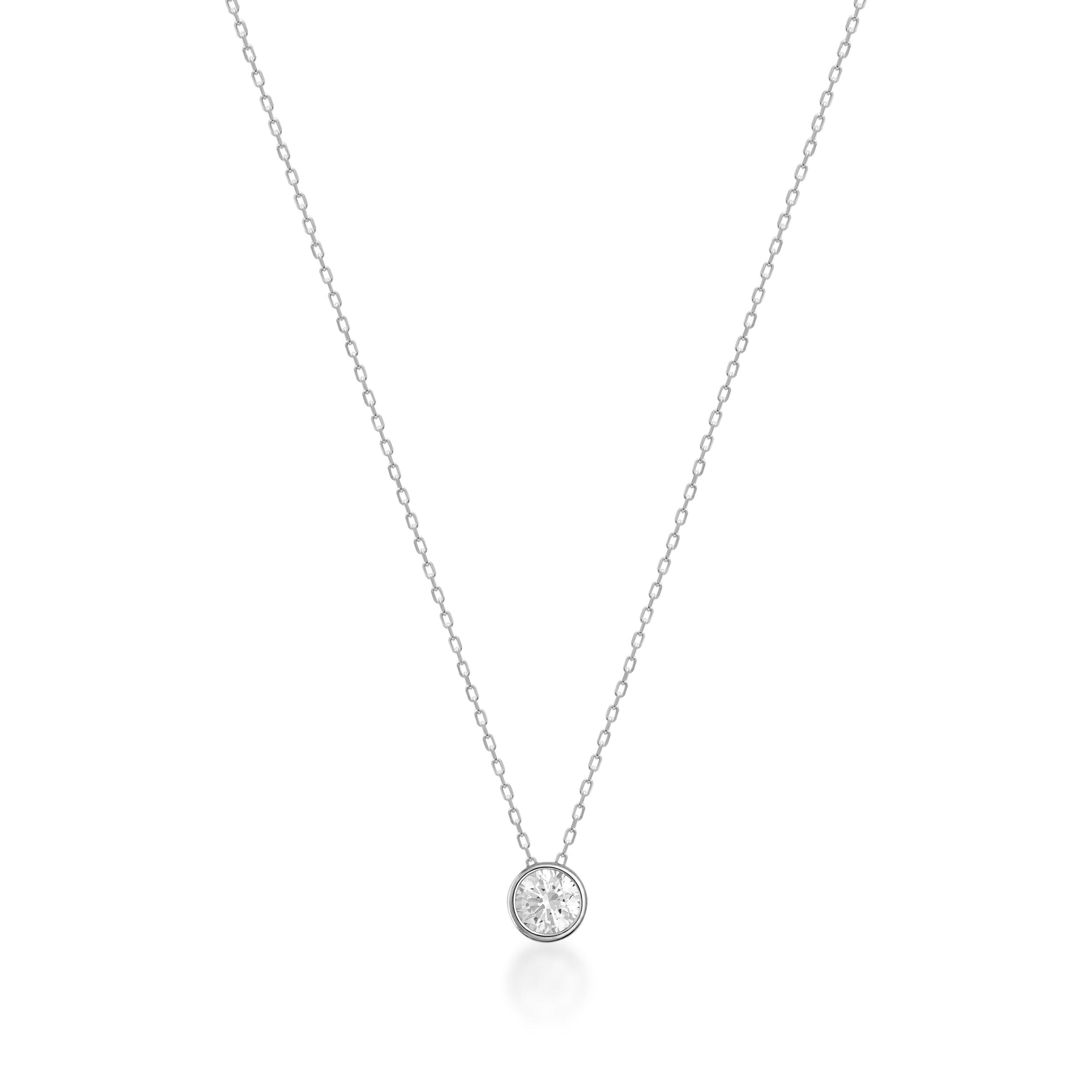 Delicate gold necklace with a round bezel-set diamond pendant on a fine chain