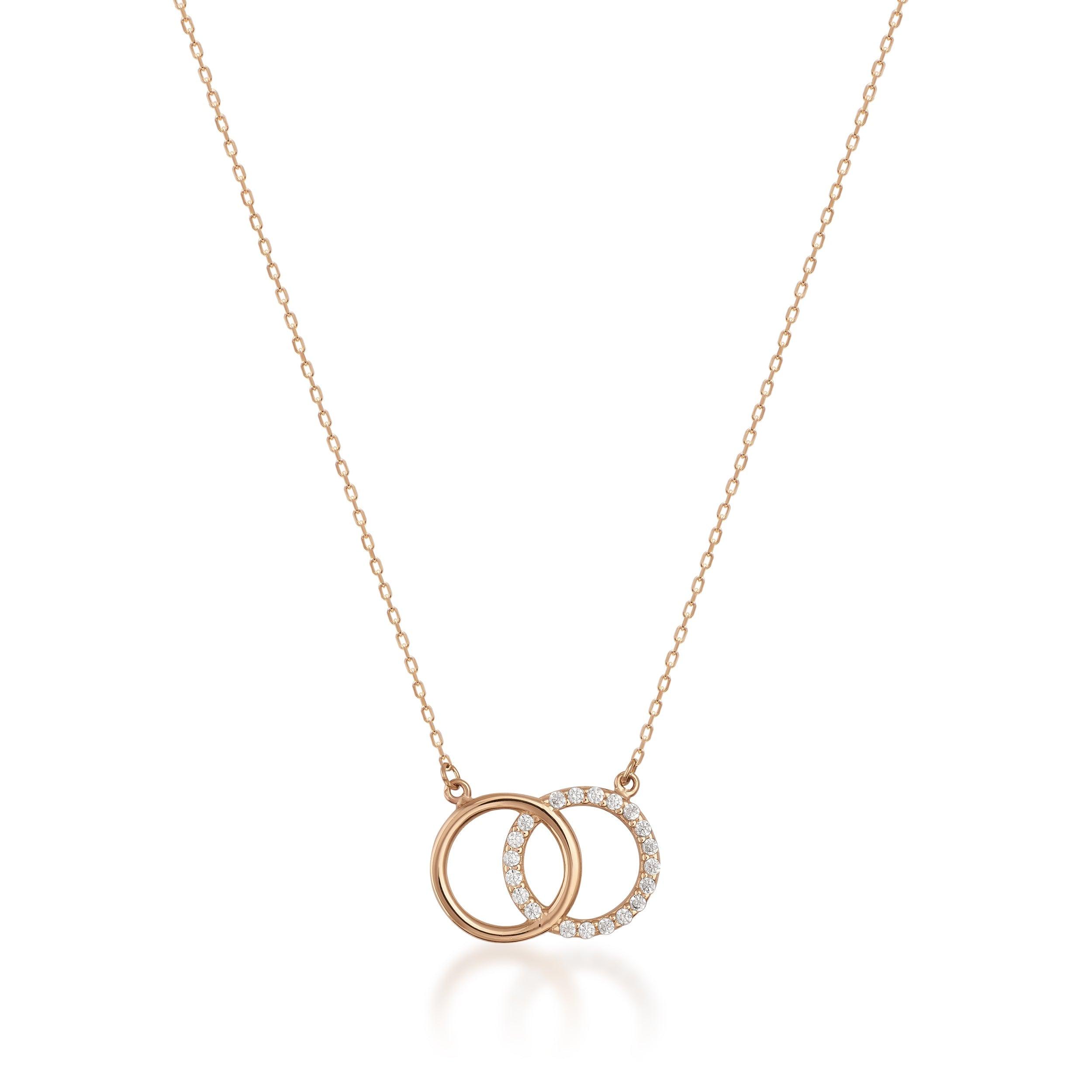 Gold necklace with two interlocking circles, one accented with small diamonds, on white background