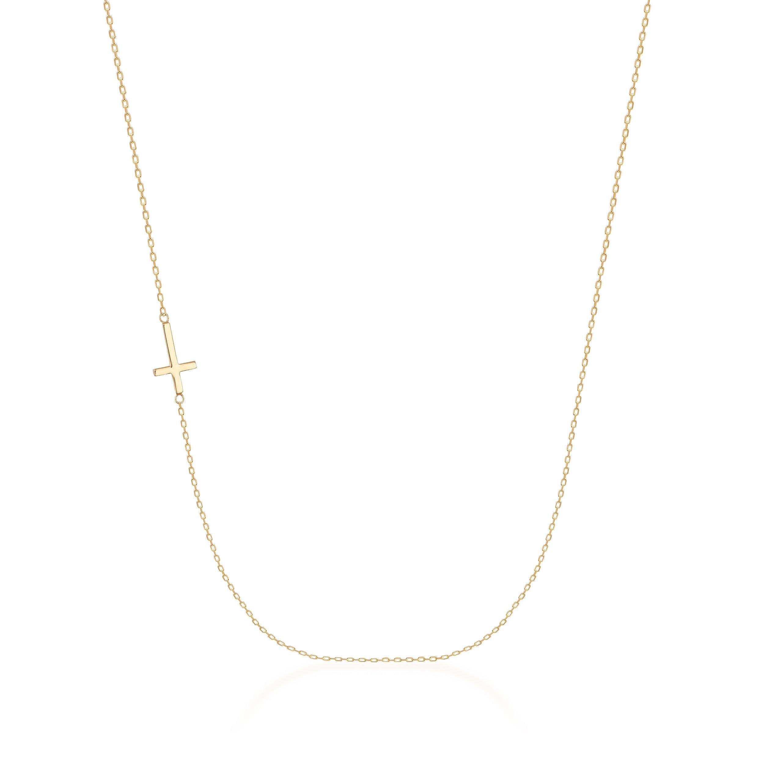 Delicate gold necklace with sideways cross pendant on fine chain, minimalist jewelry