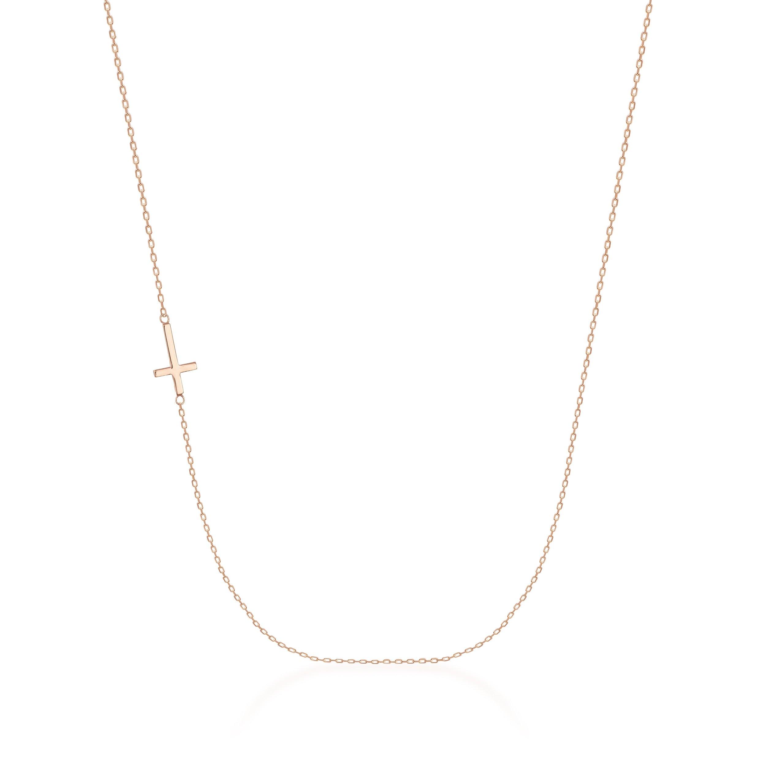 Delicate gold necklace with a sideways cross pendant on a fine chain, minimalist jewelry
