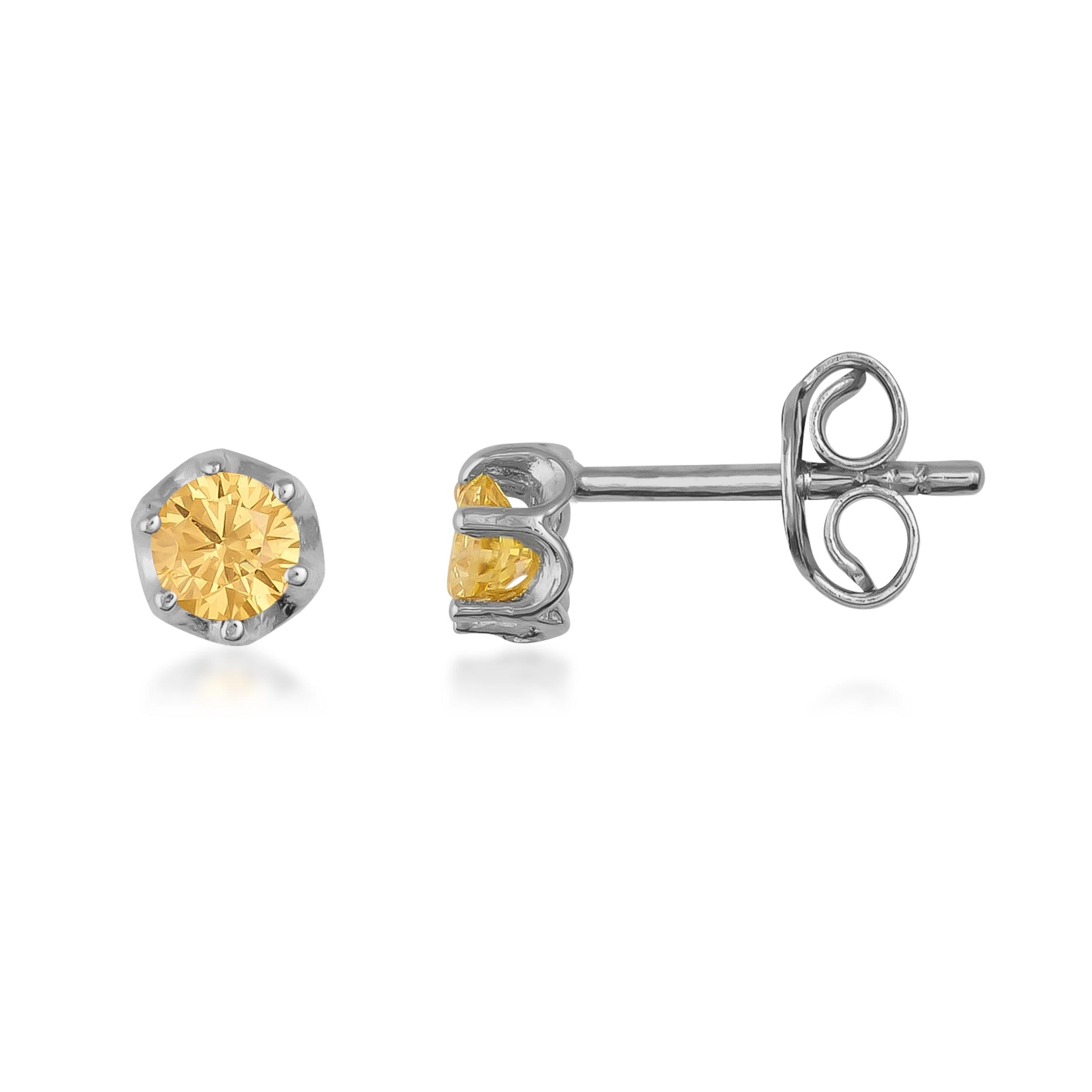 Yellow gemstone stud earrings in silver hexagon setting on white background