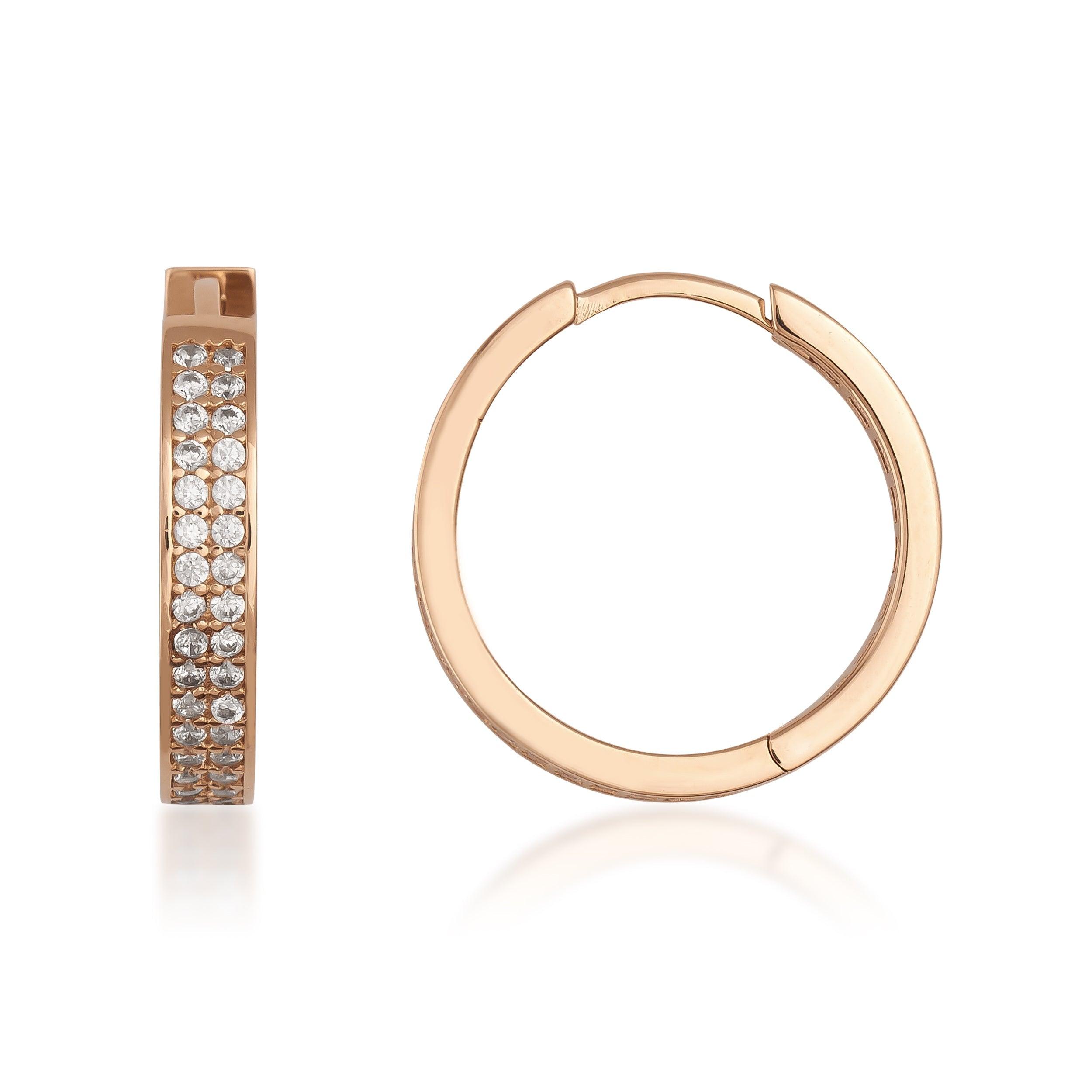 Gold hoop earrings with pavé-set clear stones against a white background