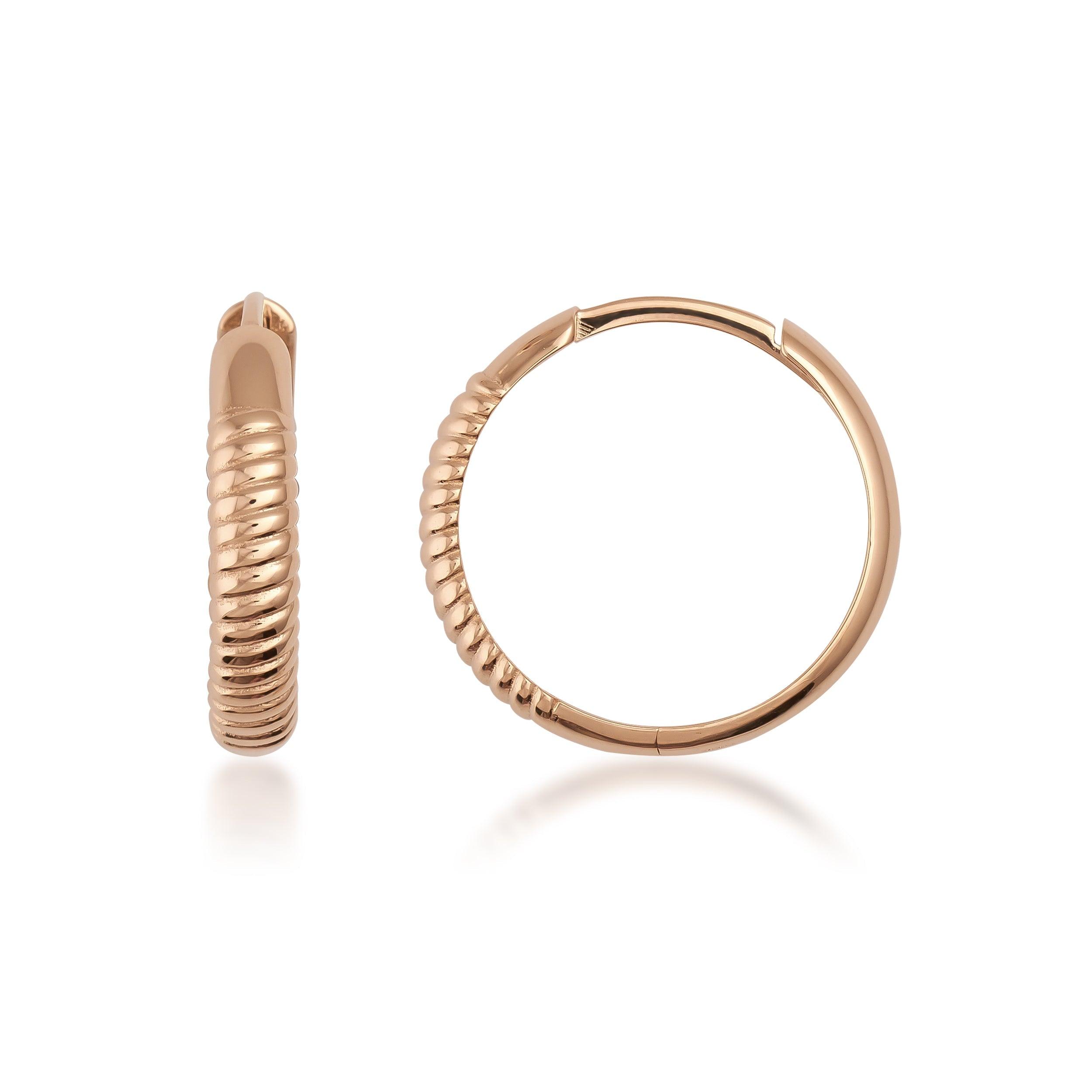 Textured gold hoop earrings with ribbed design on white background