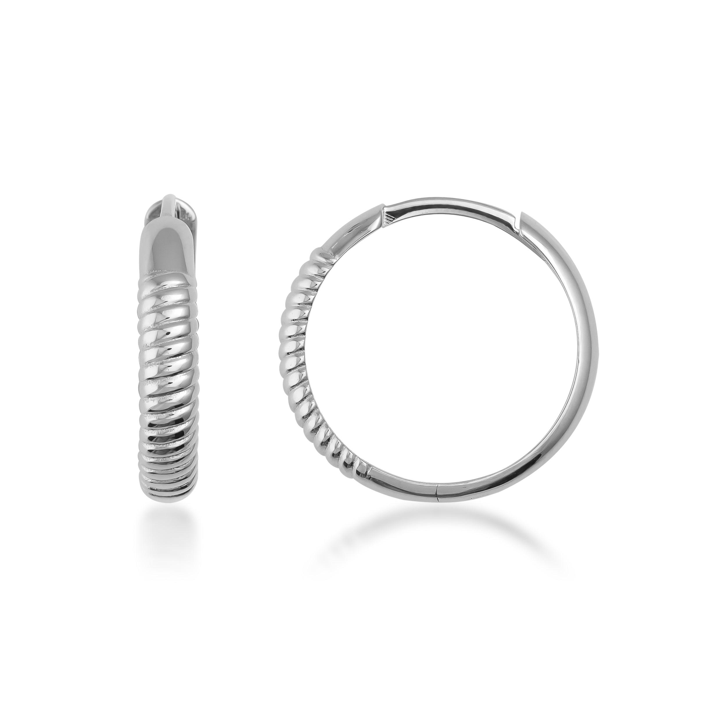 Textured white gold hoop earrings with a twisted ribbed design on a white background