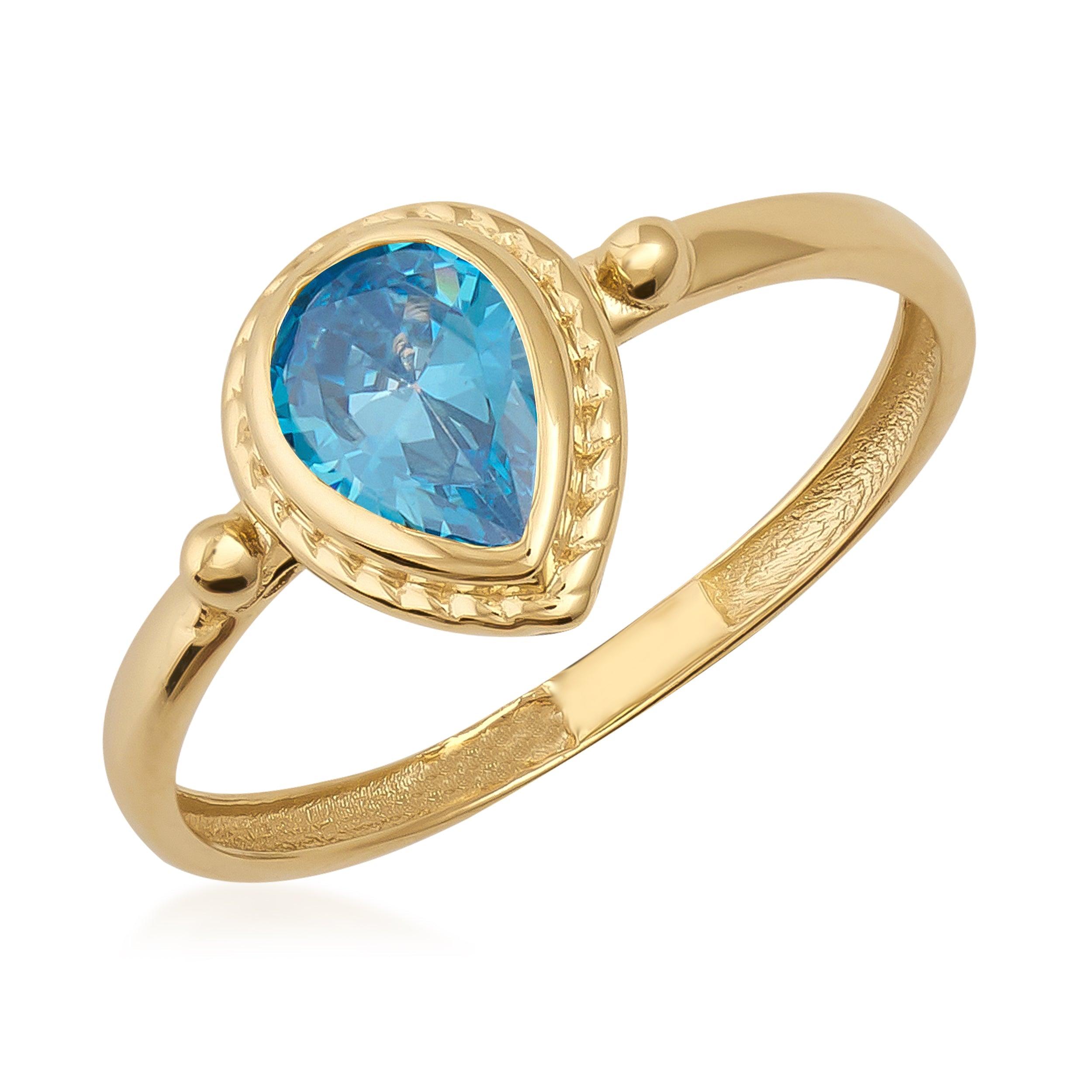 Gold ring with a pear-shaped blue gemstone, elegant and polished jewelry design