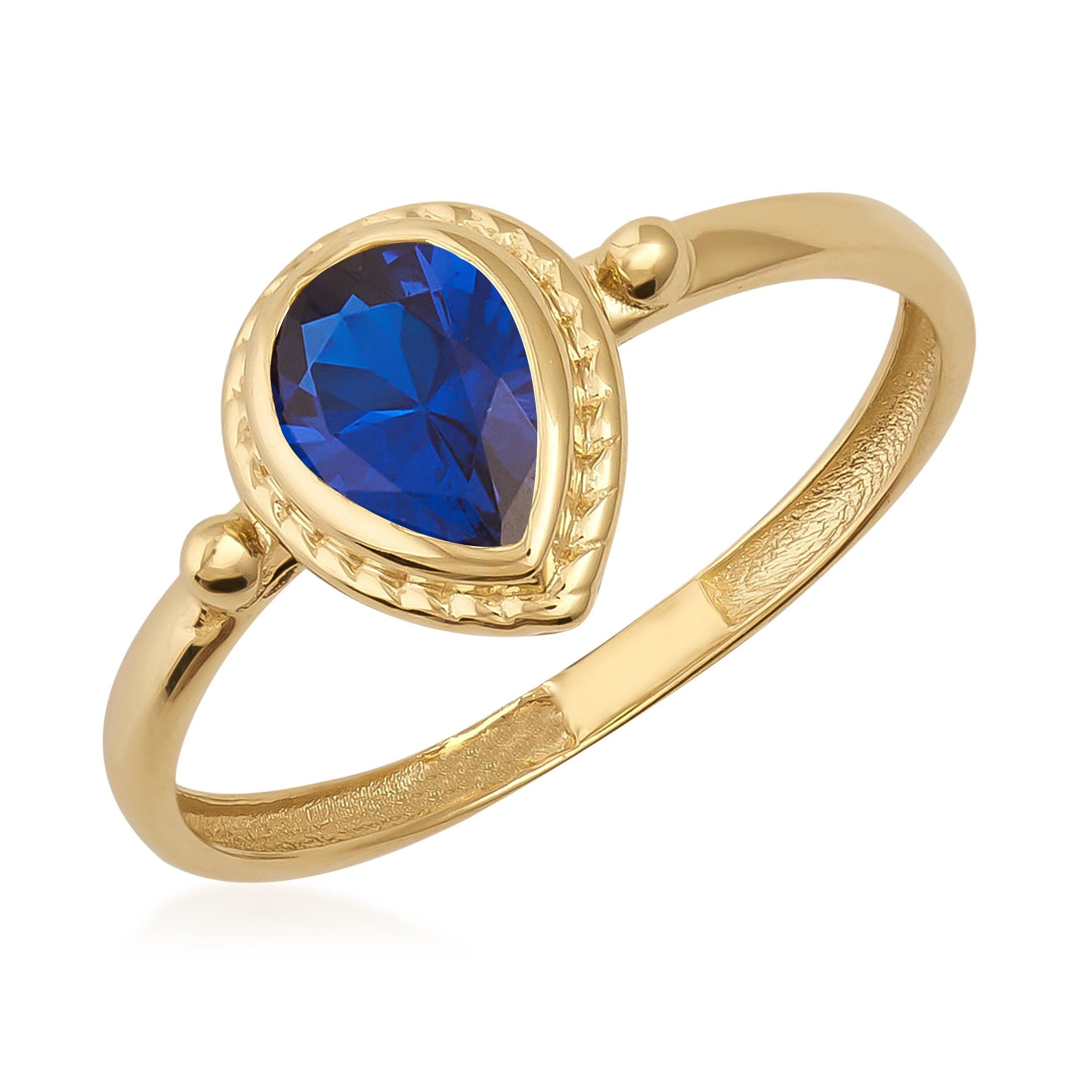 Gold ring with pear-shaped blue gemstone, elegant and detailed setting, jewelry close-up