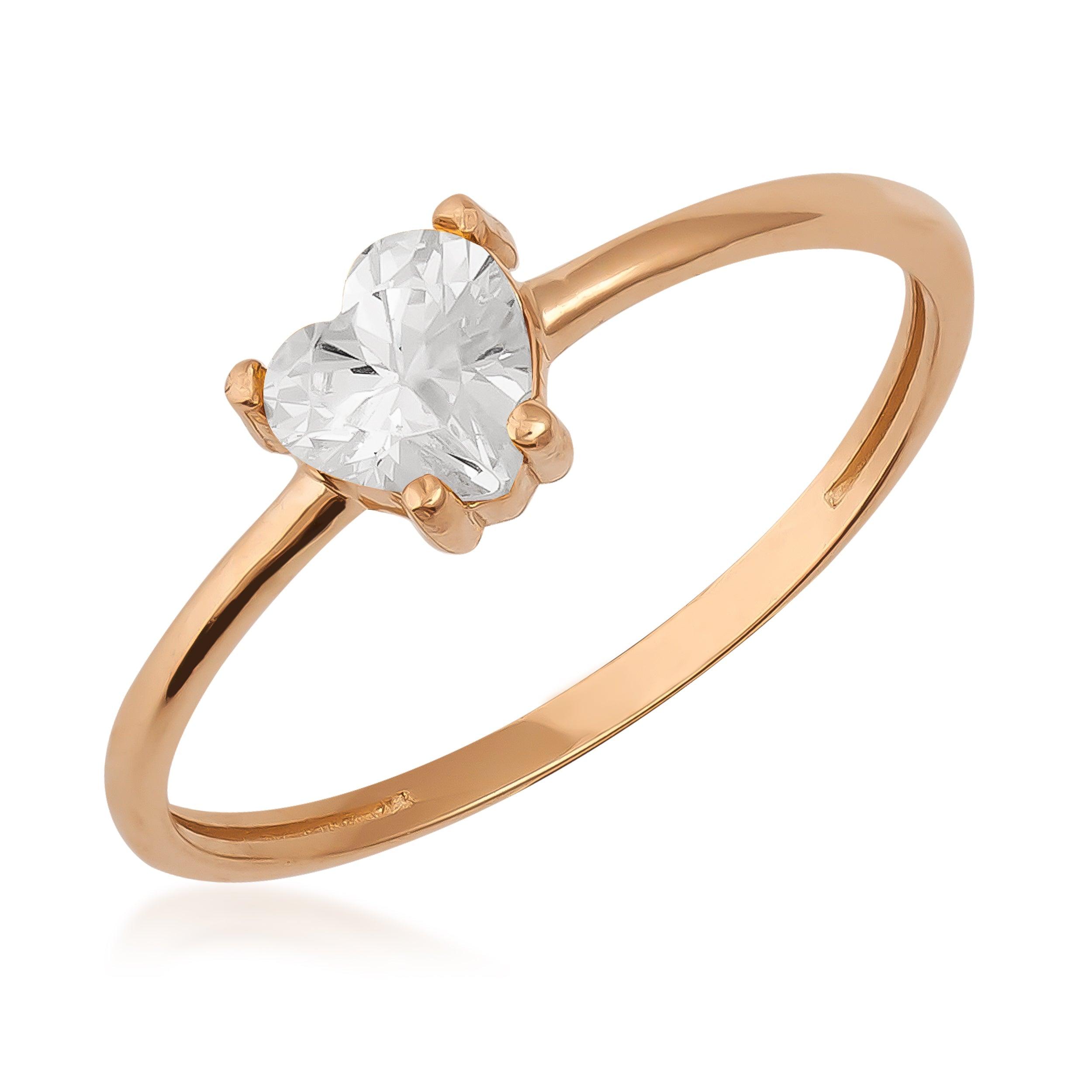Gold ring with a heart-shaped clear gemstone solitaire on a white background