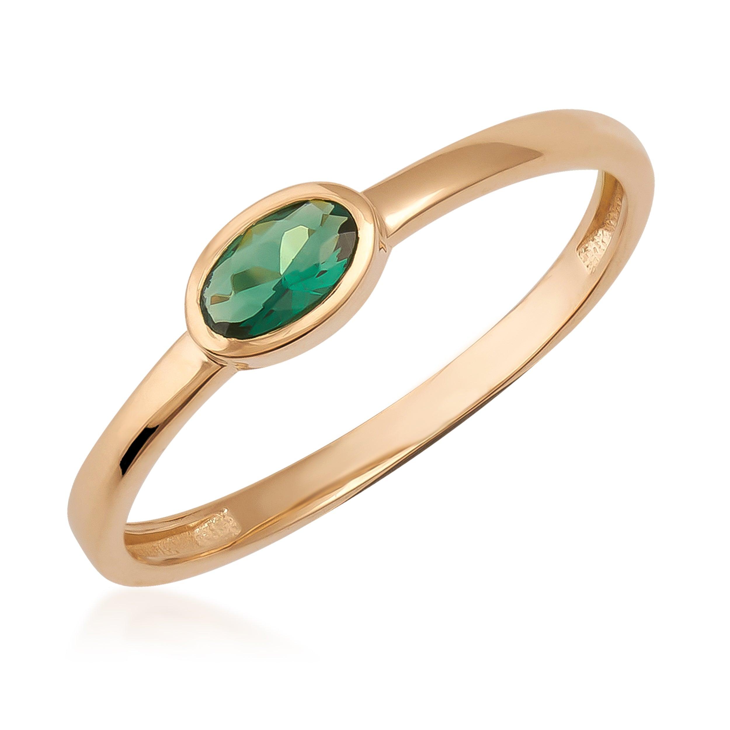 Gold ring with oval green gemstone, minimalist jewelry design, isolated on white background