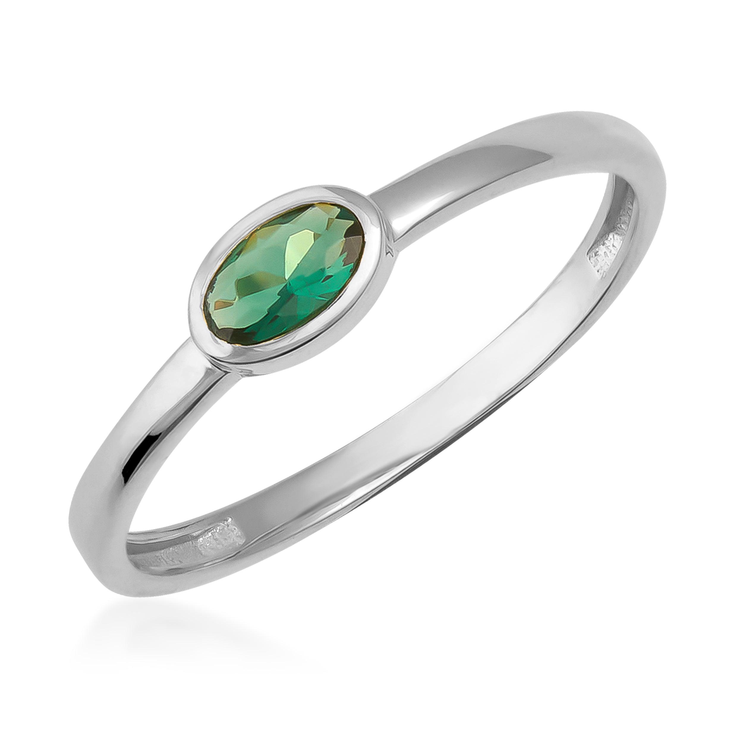 Gold ring with an oval green gemstone, minimalist jewelry design, white background