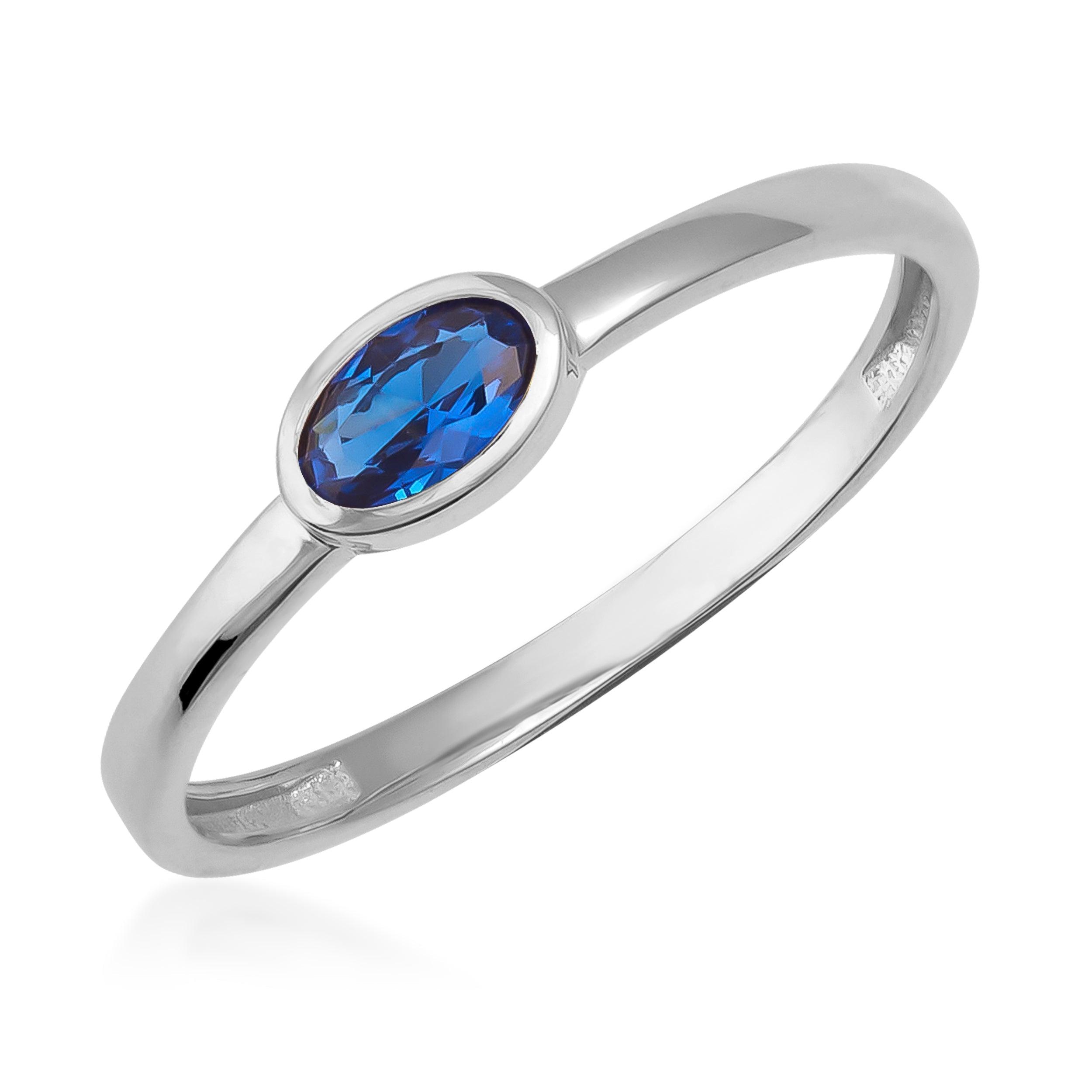 White gold ring with oval blue gemstone center, minimalist fine jewelry design