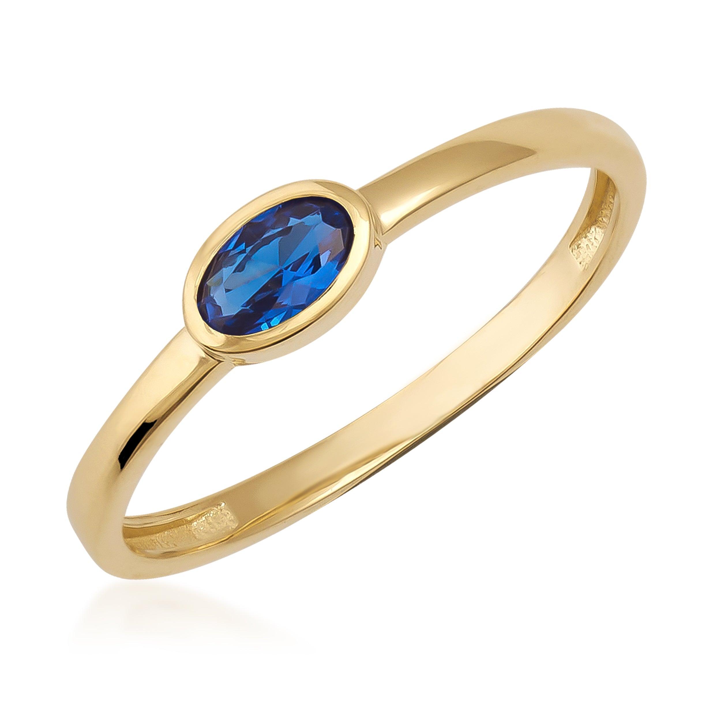Gold ring with oval blue gemstone, minimalist design, fine jewelry on white background