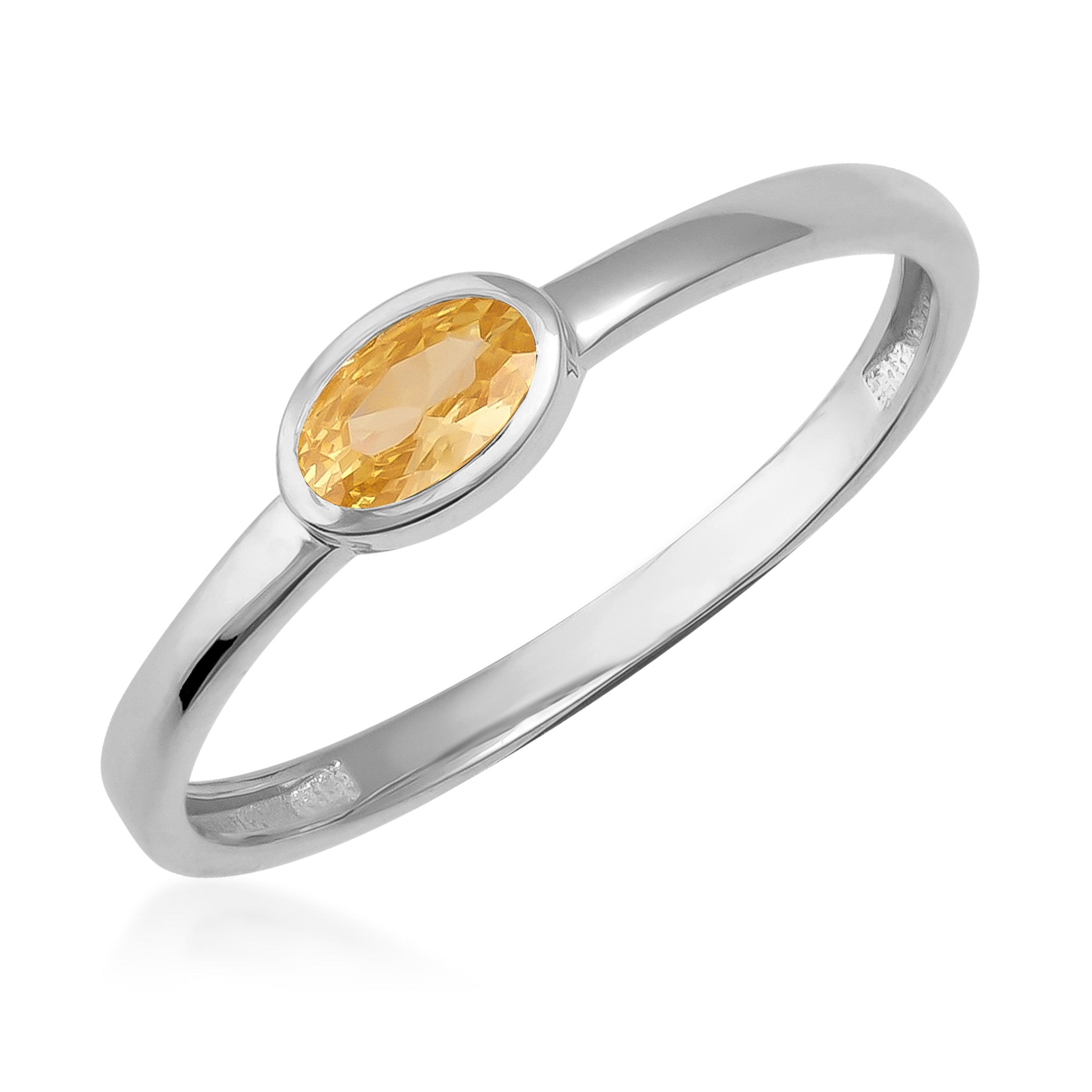 Elegant silver ring with oval yellow gemstone solitaire on white background