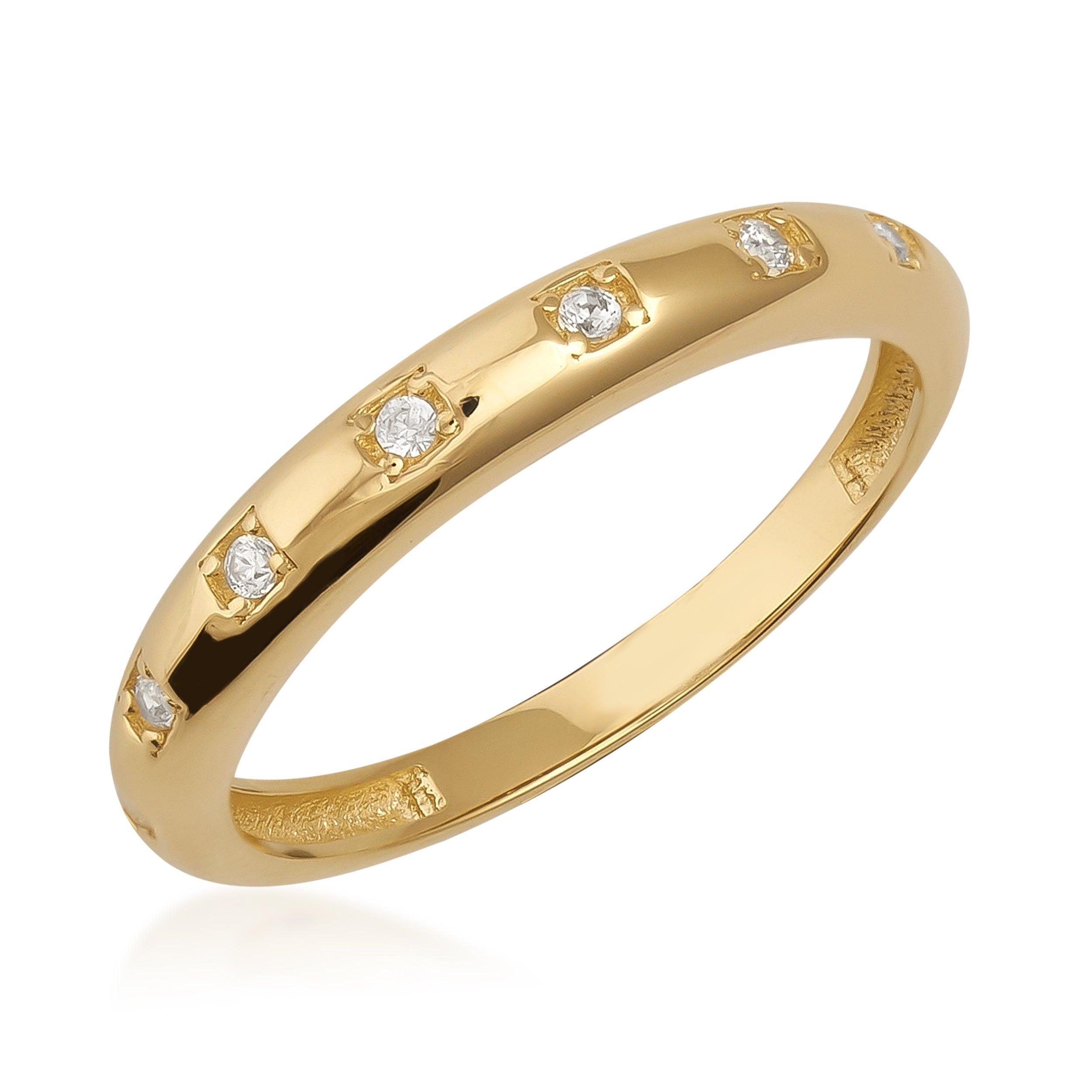 Polished gold ring with evenly spaced round diamonds in bezel settings on white background