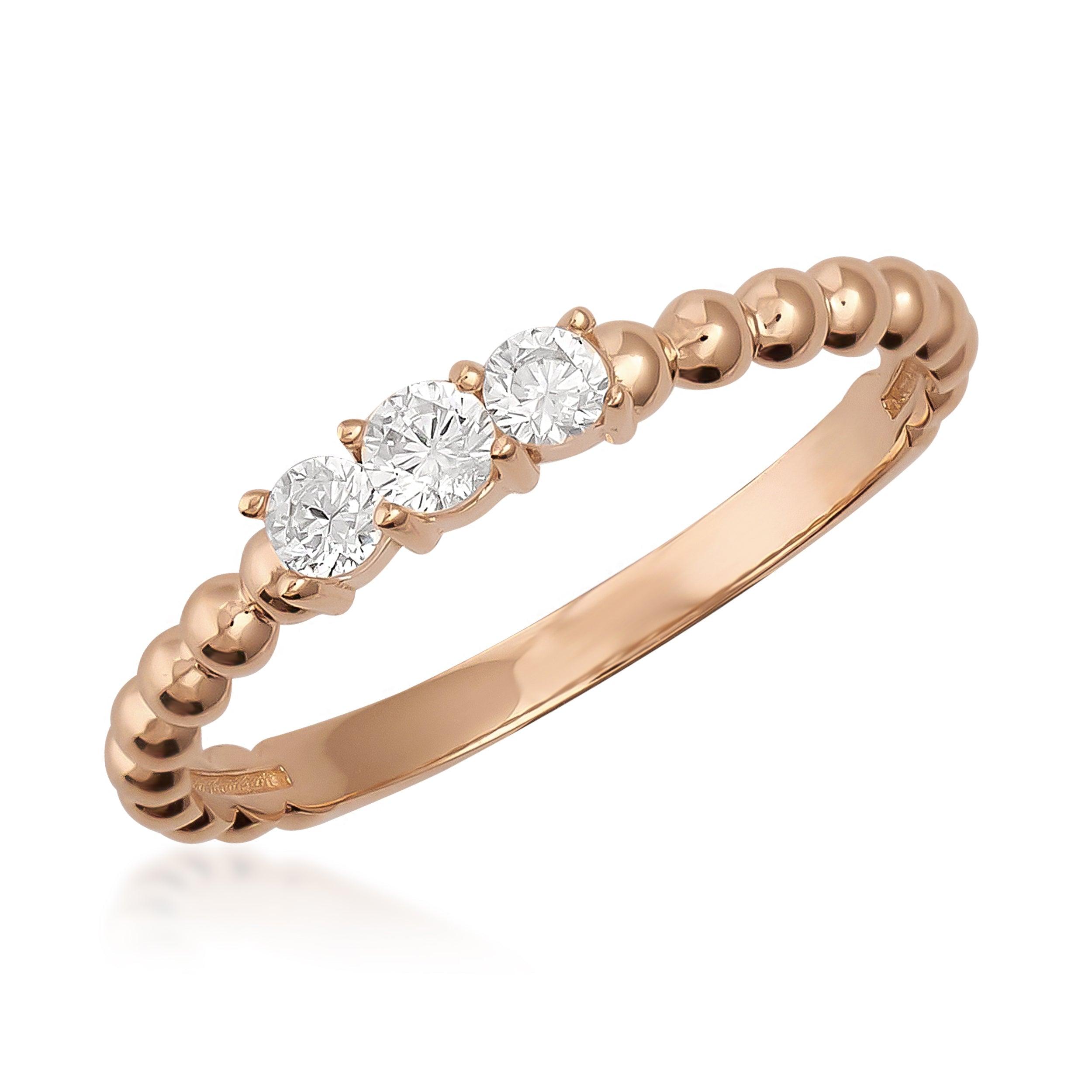 Rose gold ring with beaded band and three round-cut diamonds on white background