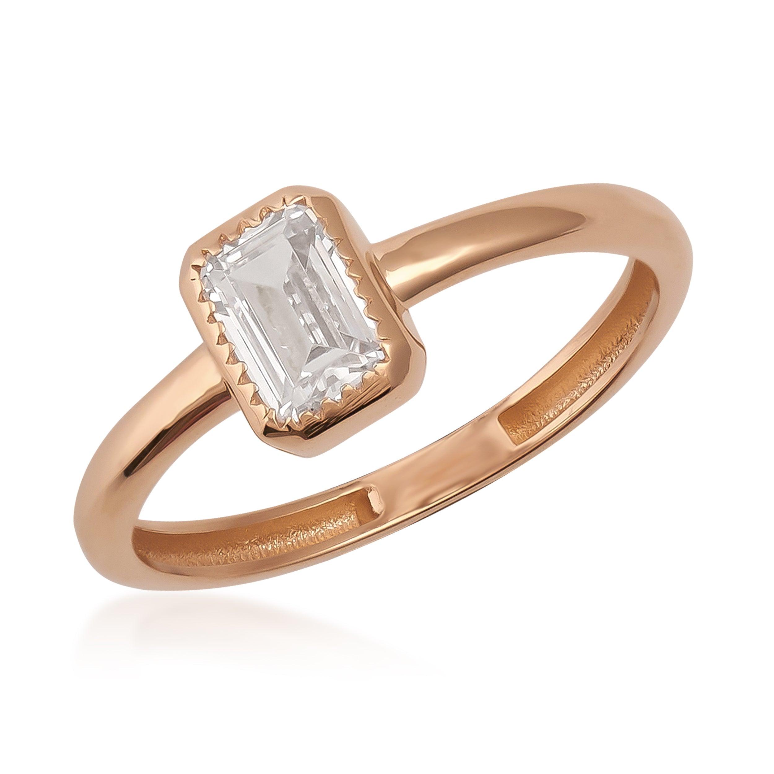Rose gold ring with emerald-cut clear gemstone on white background