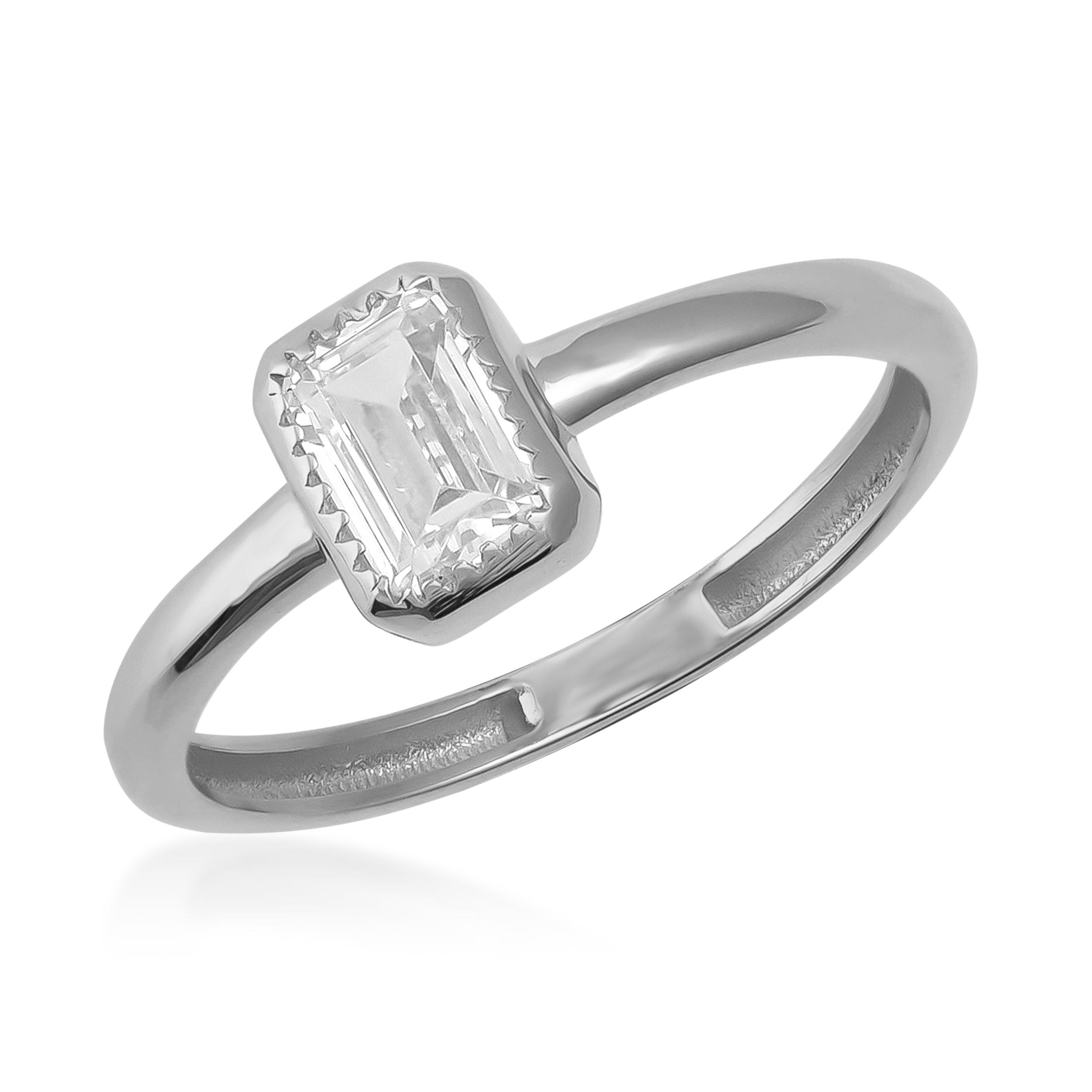 Emerald-cut solitaire diamond ring in white gold with minimalist band on white background