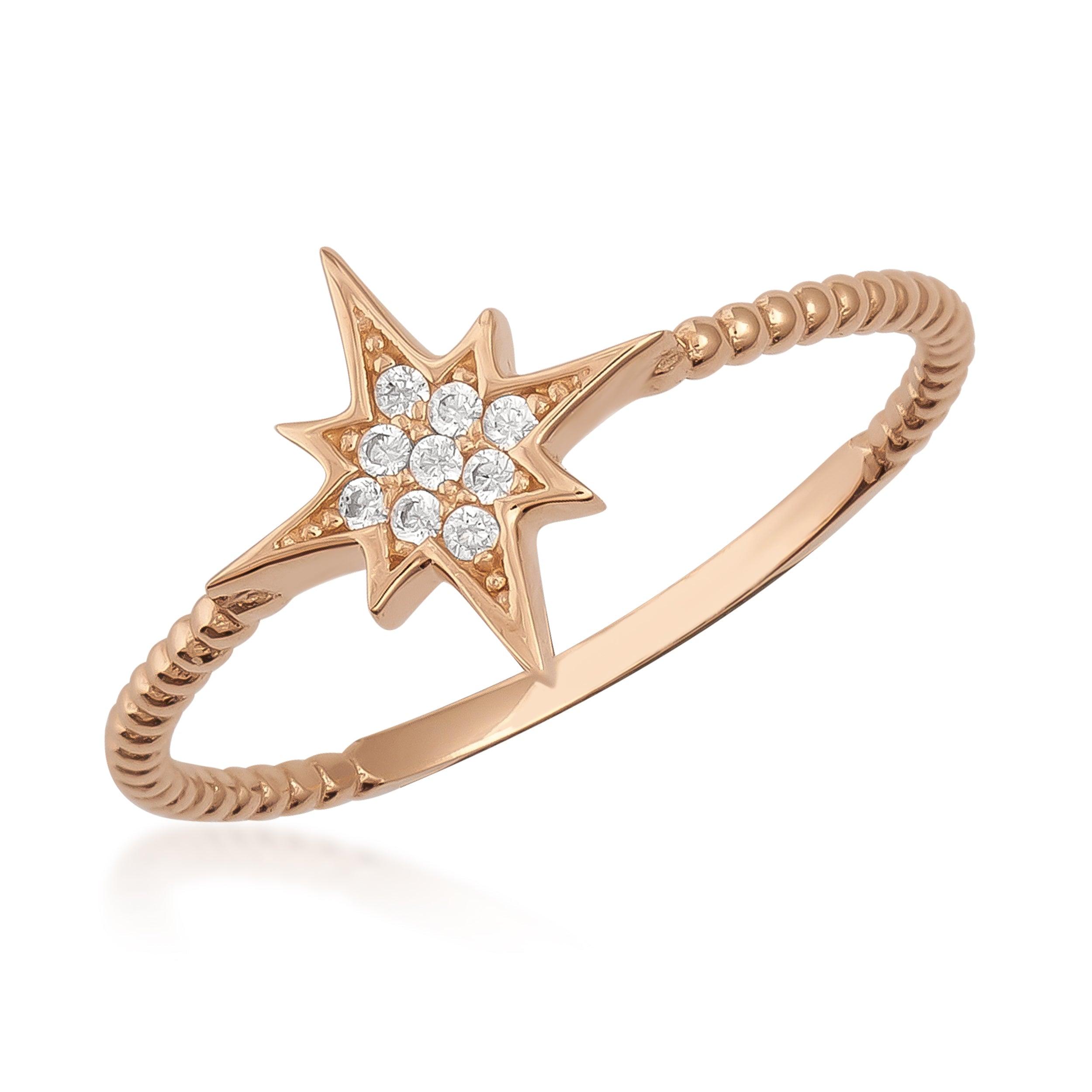 Gold starburst ring with diamond accents and twisted band on white background