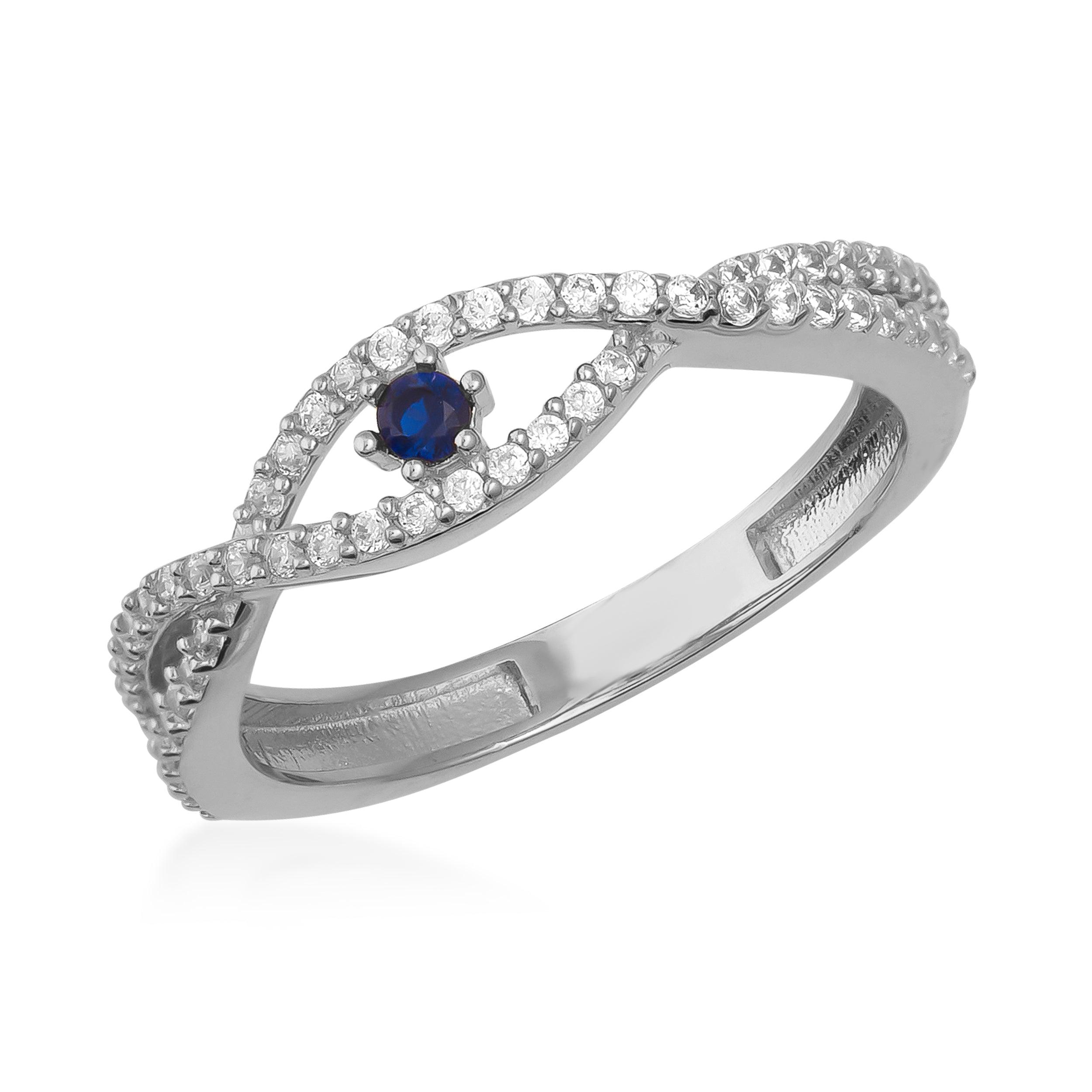 White gold ring with a blue sapphire center stone and twisted band set with clear gemstones