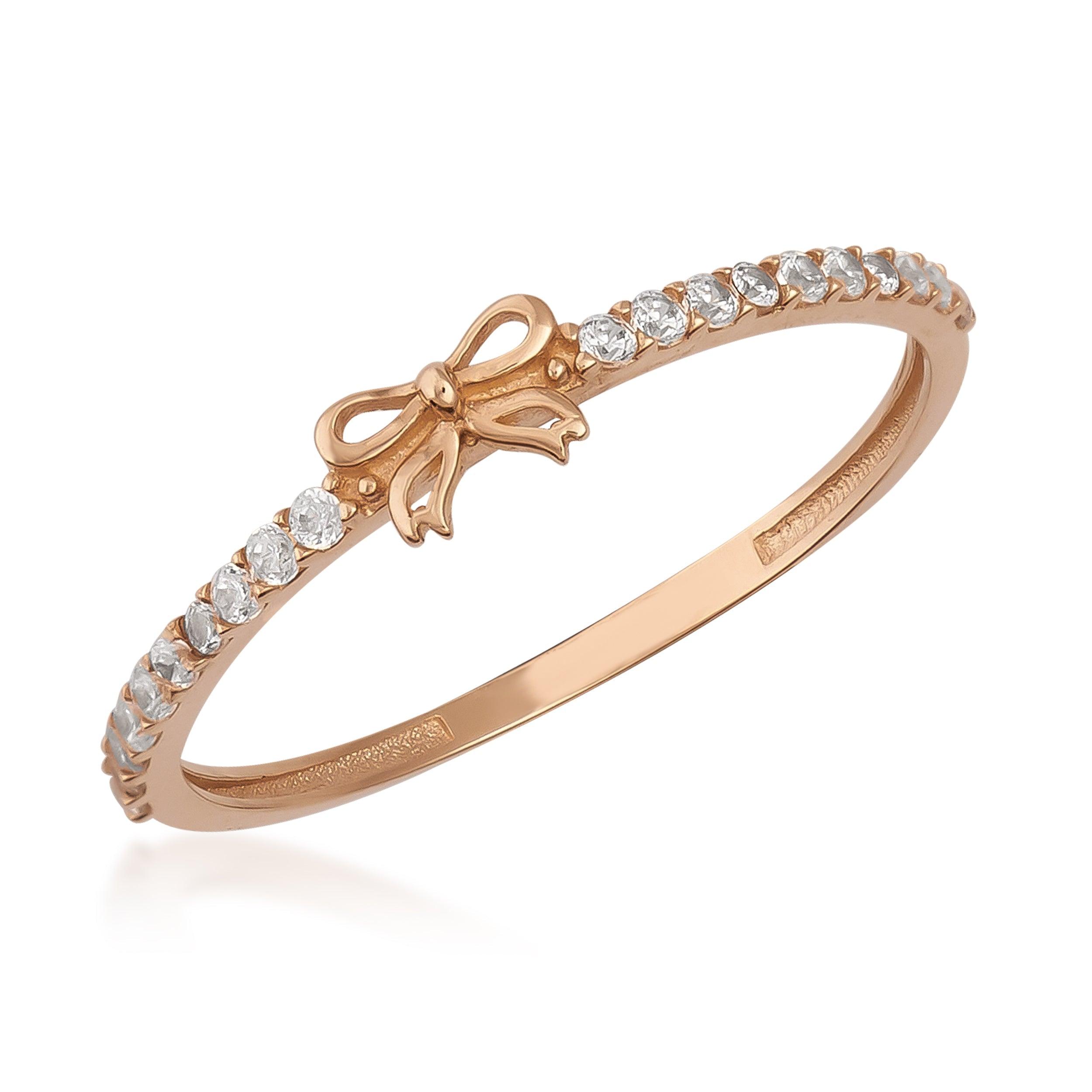Rose gold ring with bow design and round white gemstones on band, elegant jewelry