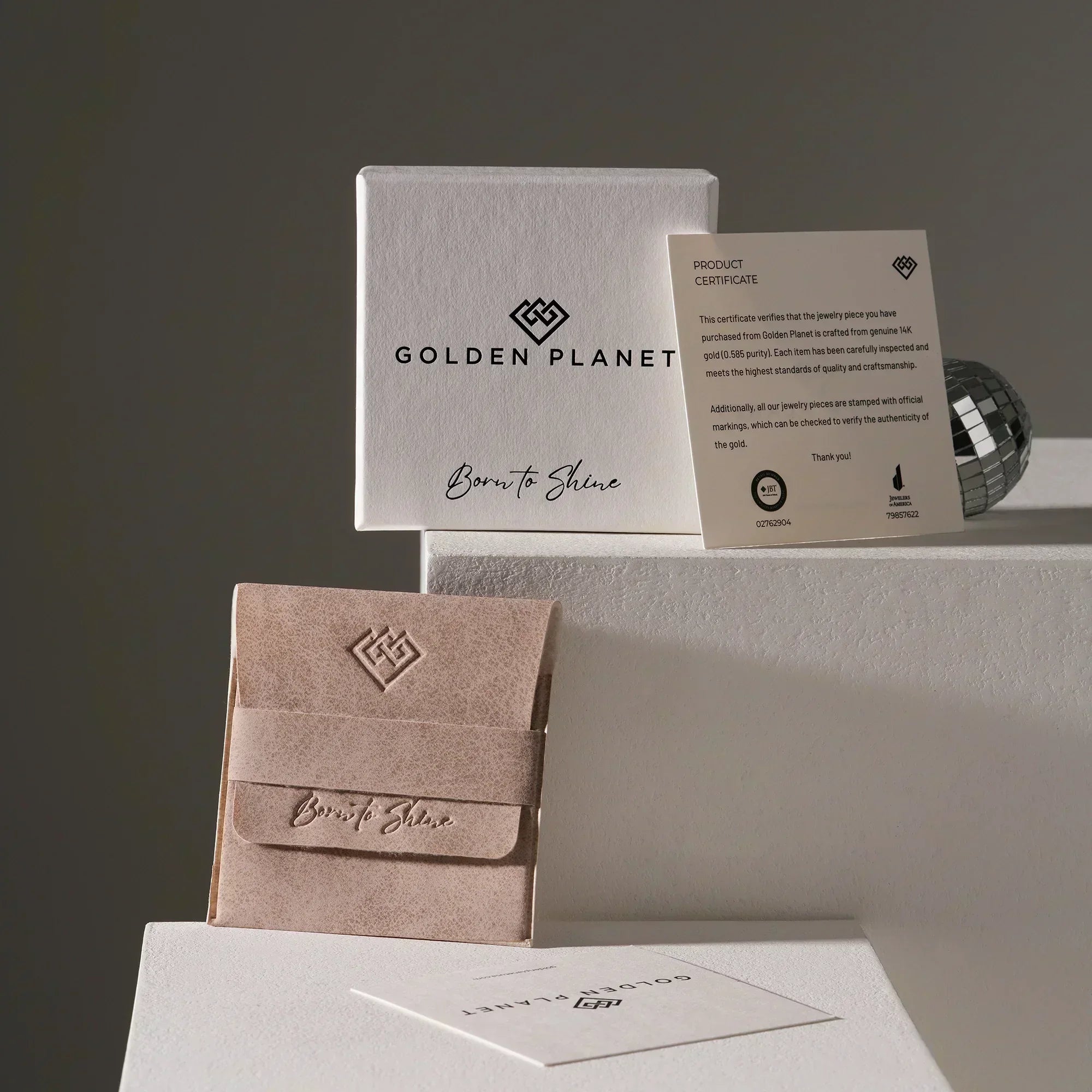 Jewelry packaging with 'Golden Planet' branding on a neutral background