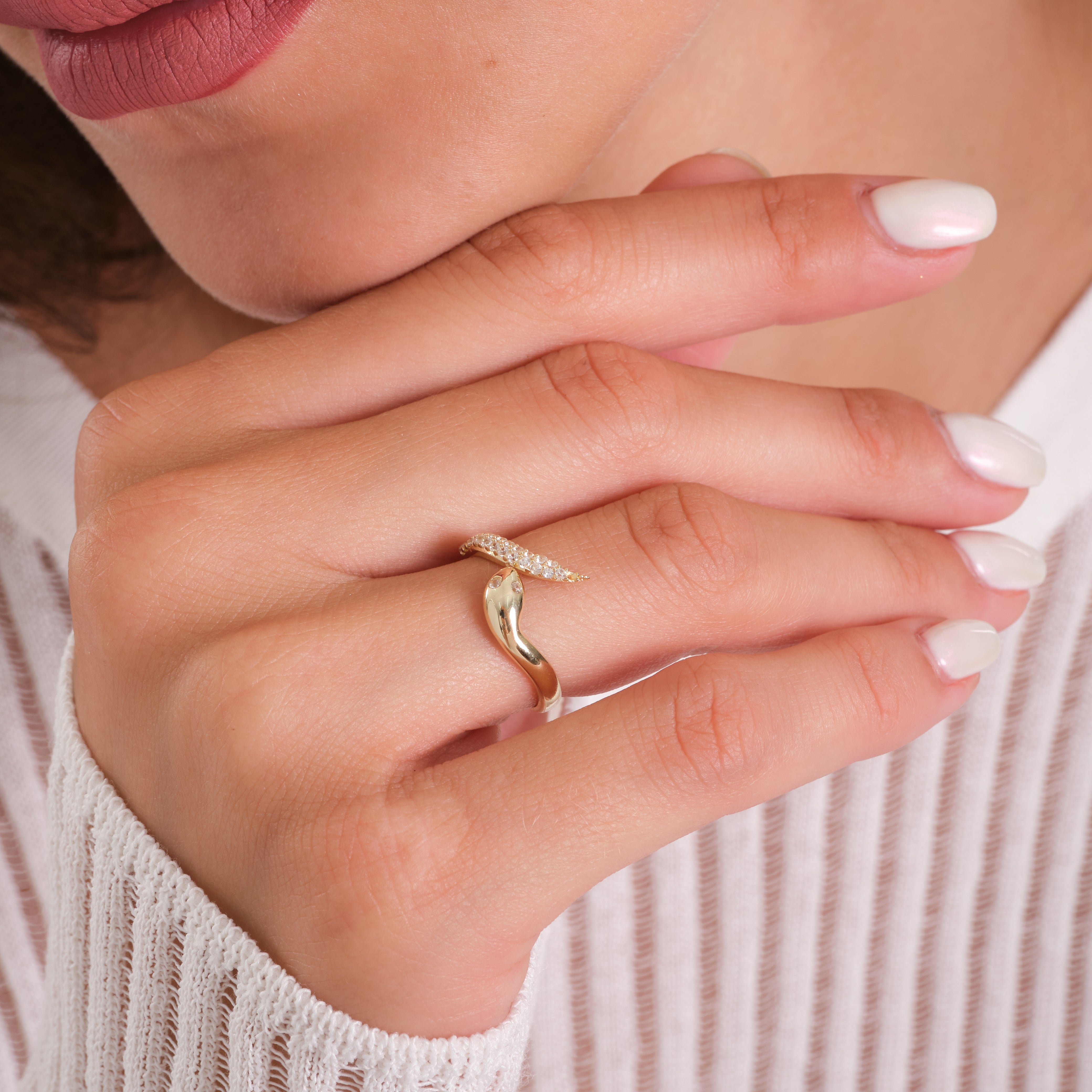 Close-up of a hand wearing a gold ring with a blurred background