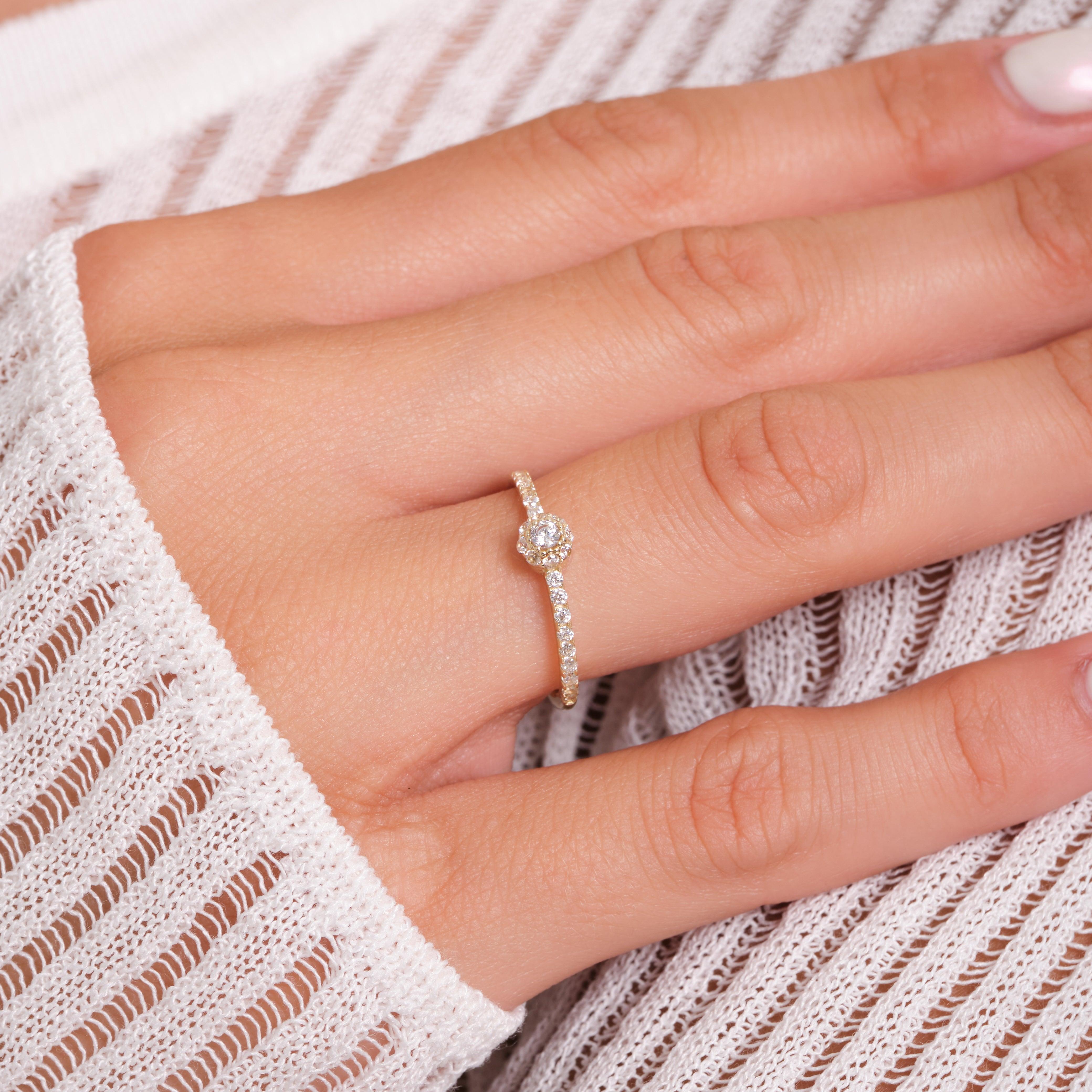 Diamond halo gold ring on hand, delicate gold jewelry with sparkling stones