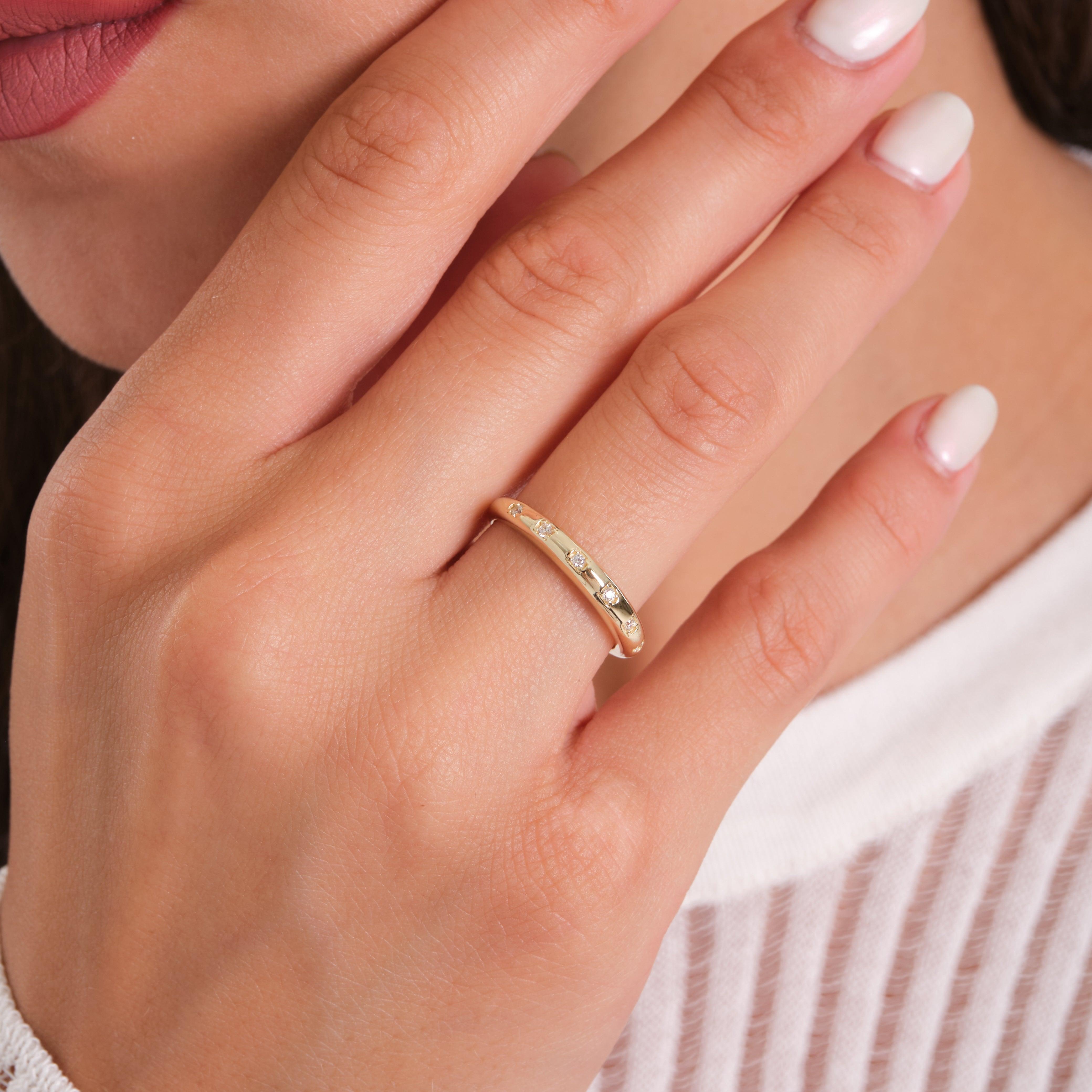 Gold ring with small diamonds on woman's hand, close-up, elegant jewelry design