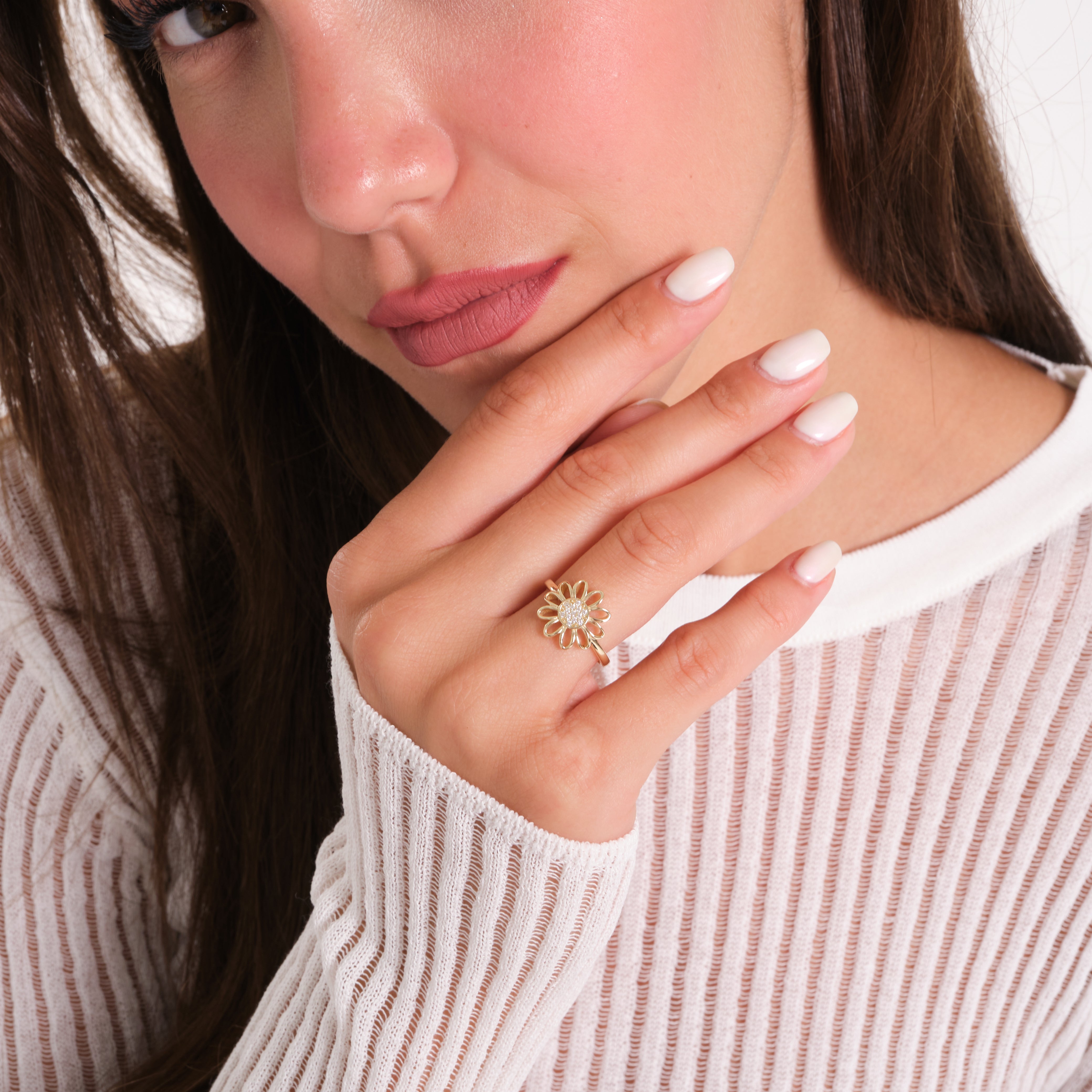 Close-up of a woman wearing a gold ring with a pearl center.