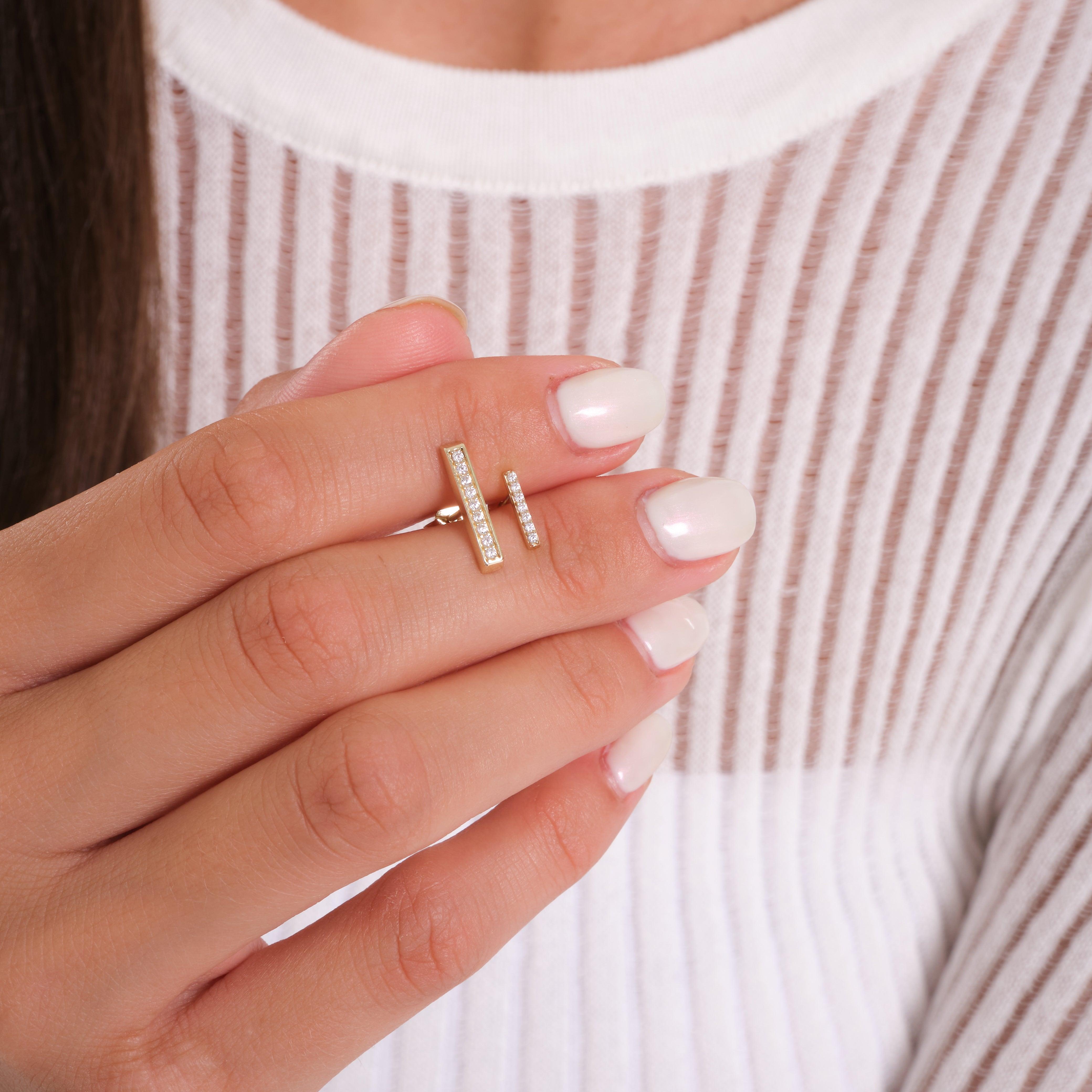 Woman wearing a gold bar ring with small diamonds, elegant jewelry on manicured hand