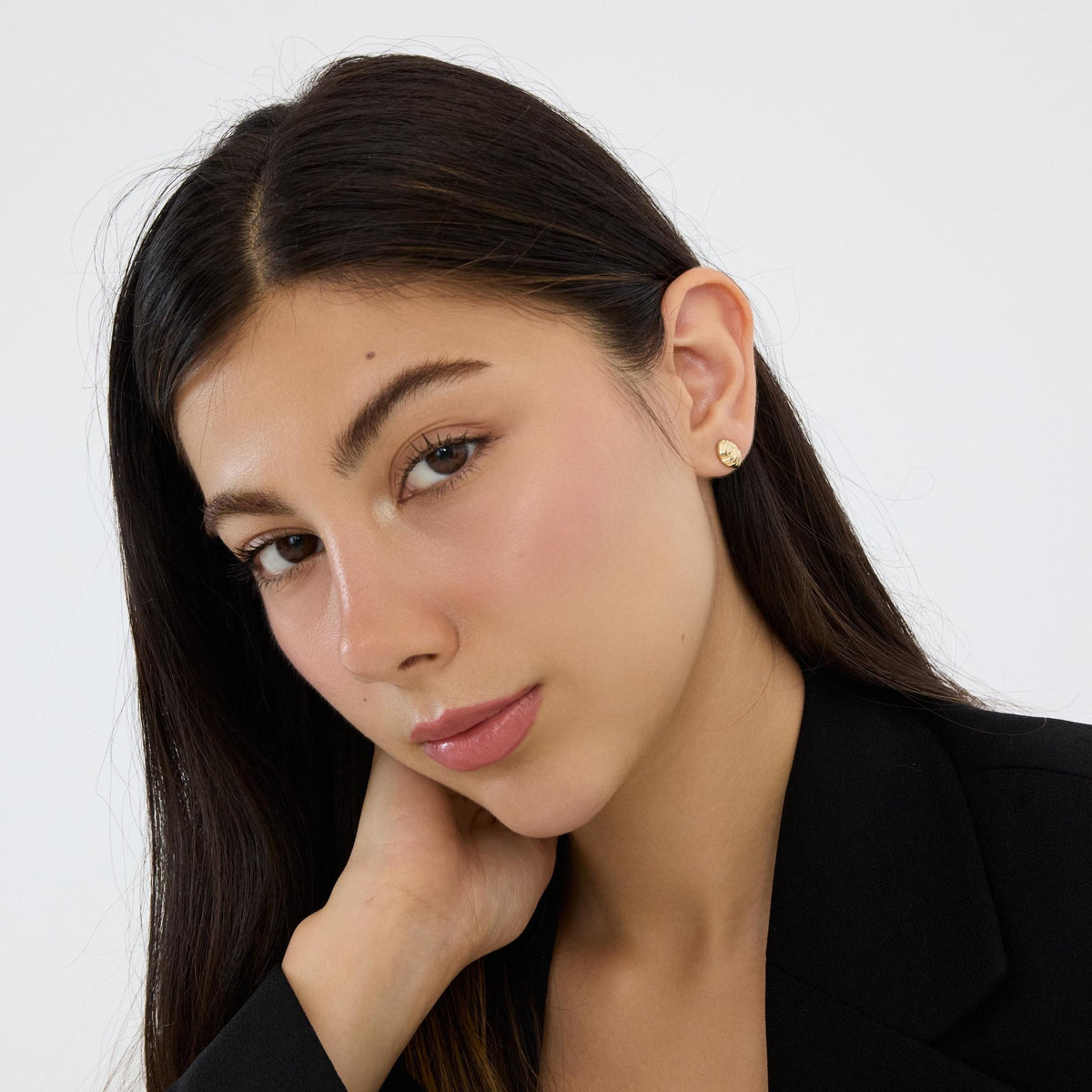 14K gold braided knot stud earring worn by woman resting head on hand, three-quarter view
