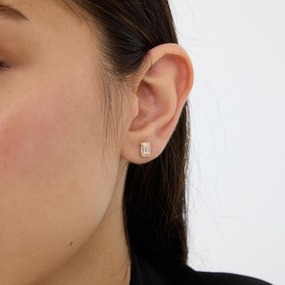 14K gold cluster stud earring with cubic zirconia worn in the ear, side view of the lobe