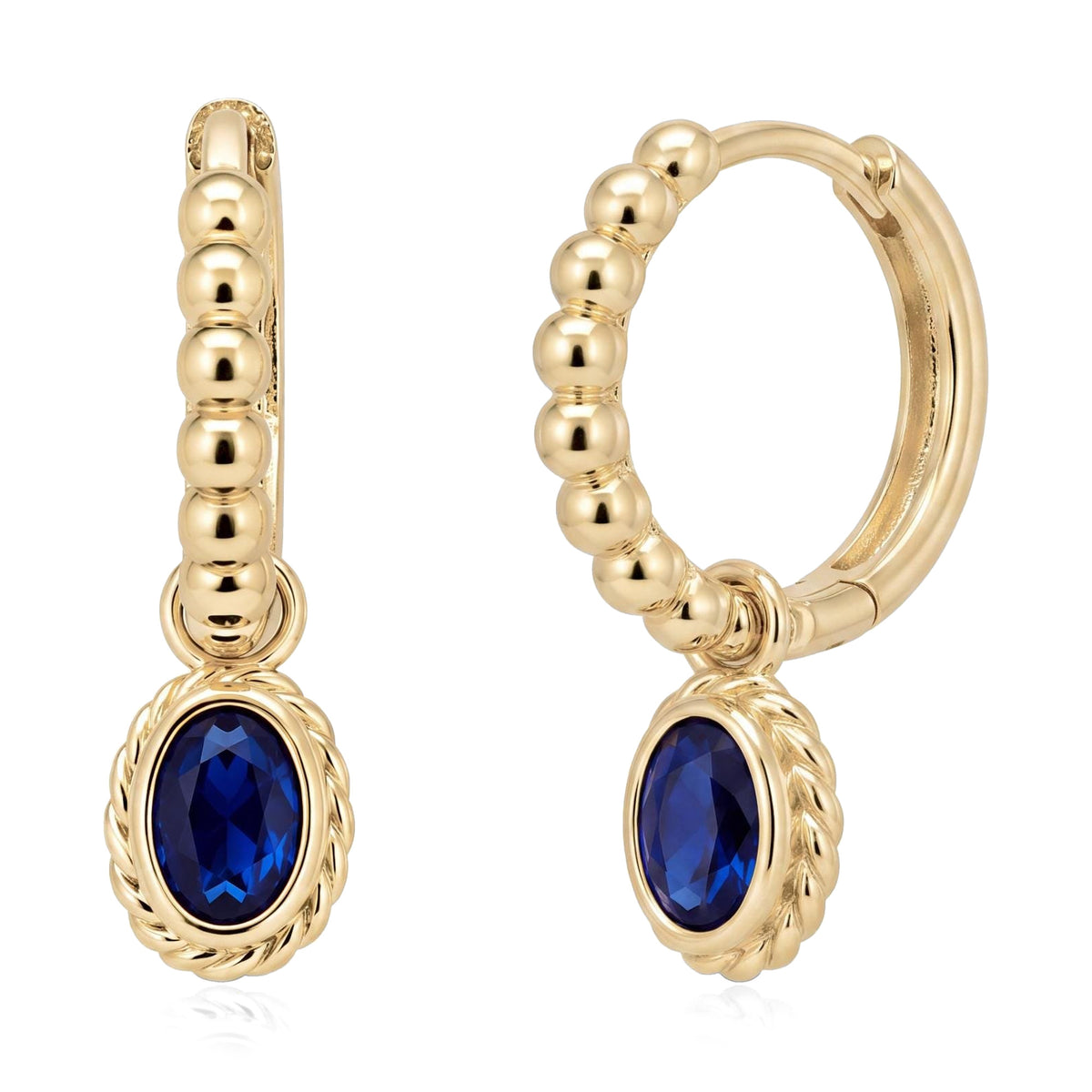 Pair of 14K yellow gold beaded huggie earrings with oval blue stone drops and twisted rope bezel