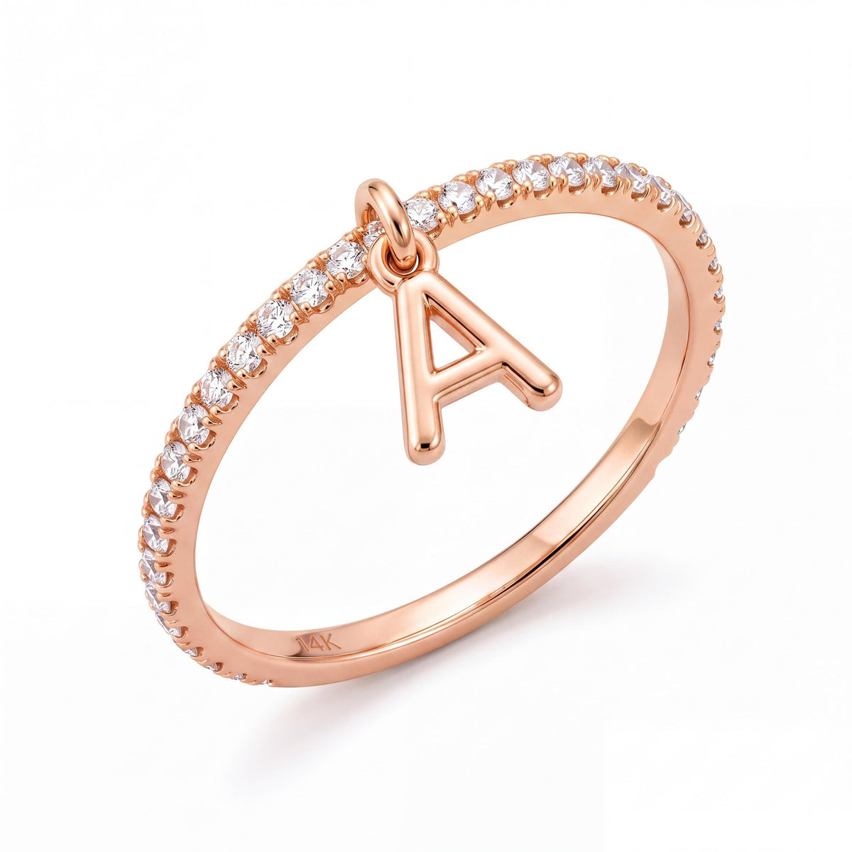 14K rose gold dangle initial ring, thin clear stone pavé band with a hanging letter A charm, on white