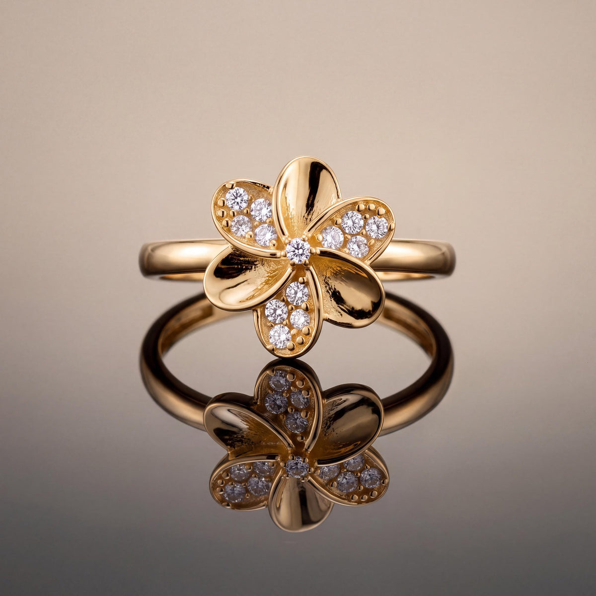 14K yellow gold flower ring standing upright on a reflective surface against a beige backdrop