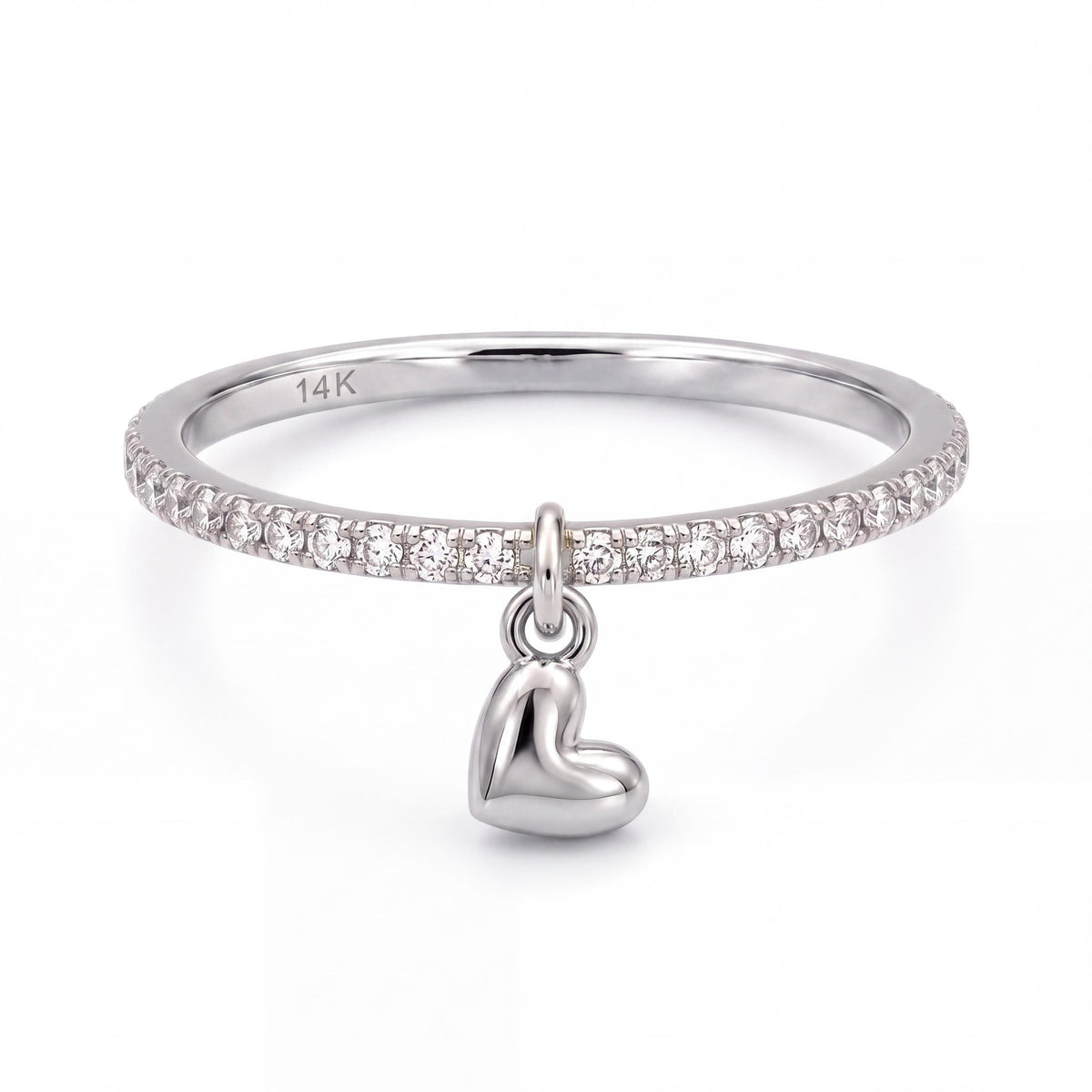 14K white gold heart charm ring, clear stone band with a dangling puffed heart, front view on white