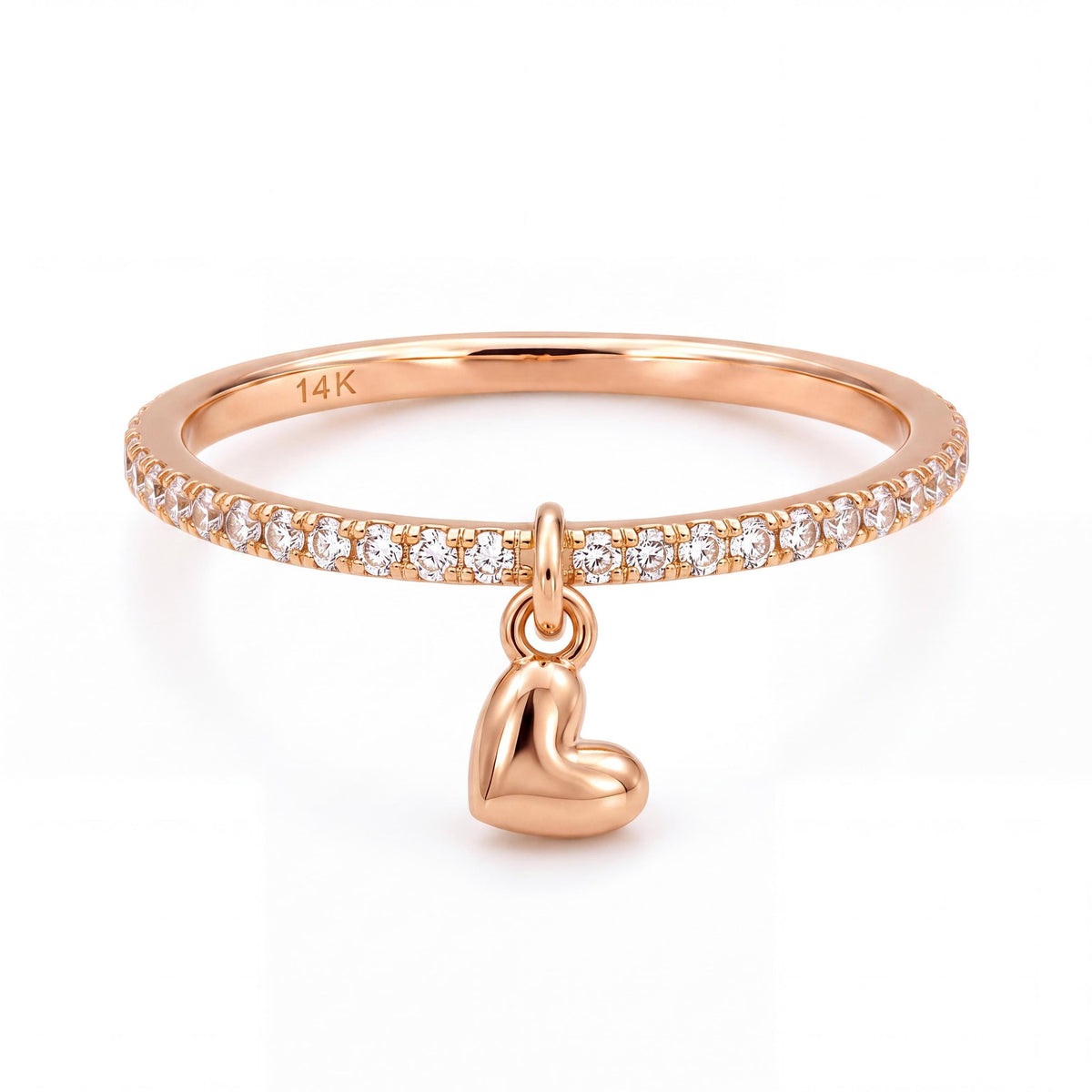 14K rose gold heart charm ring, clear stone band with a dangling puffed heart, front view on white
