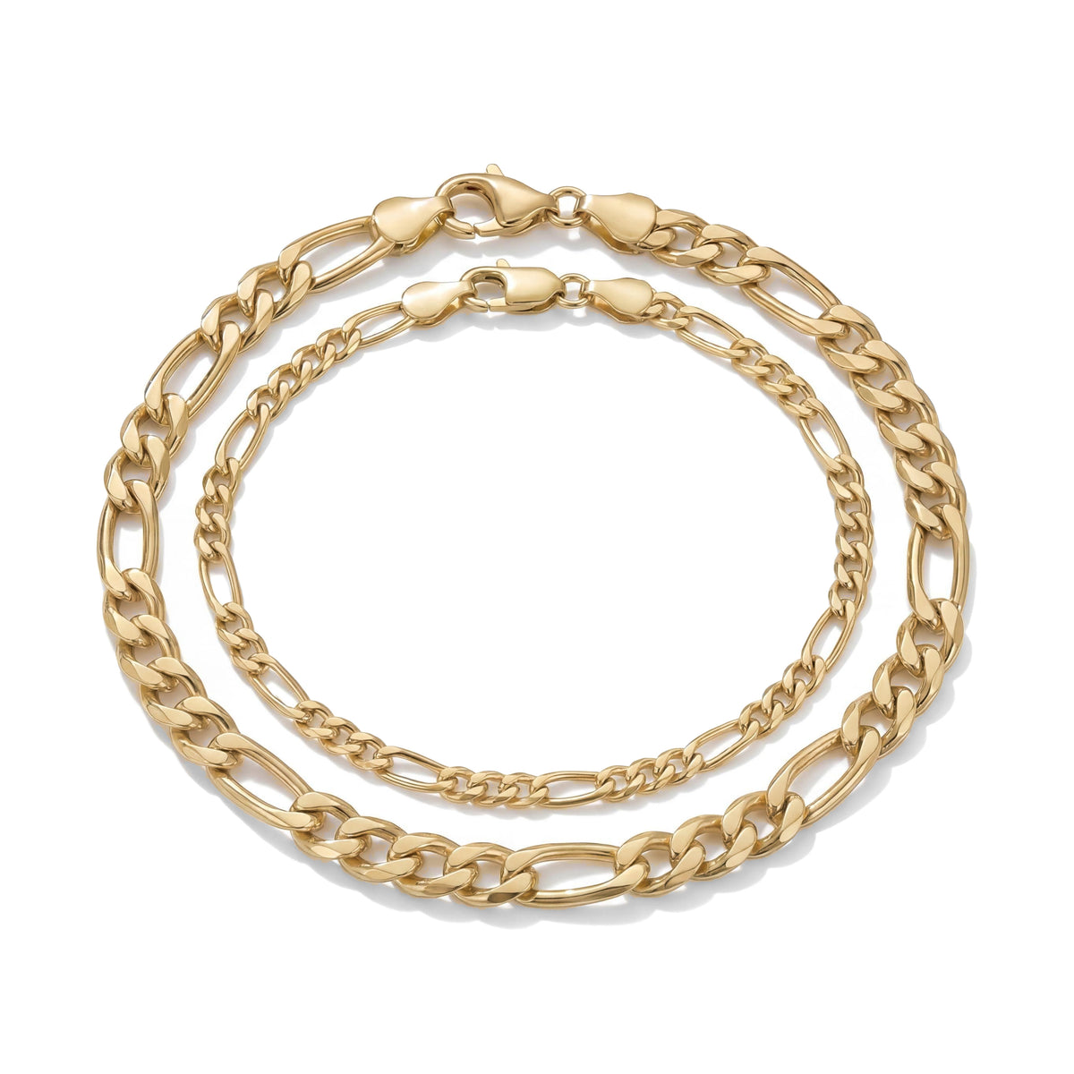 14K yellow gold figaro chain bracelets in two widths, nested with lobster clasps on white