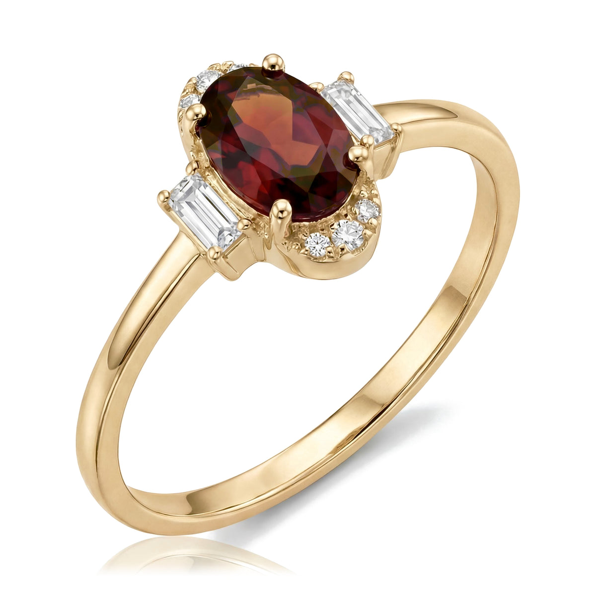 14K yellow gold simulated ruby ring, oval dark red stone flanked by baguette accents, angled view on white