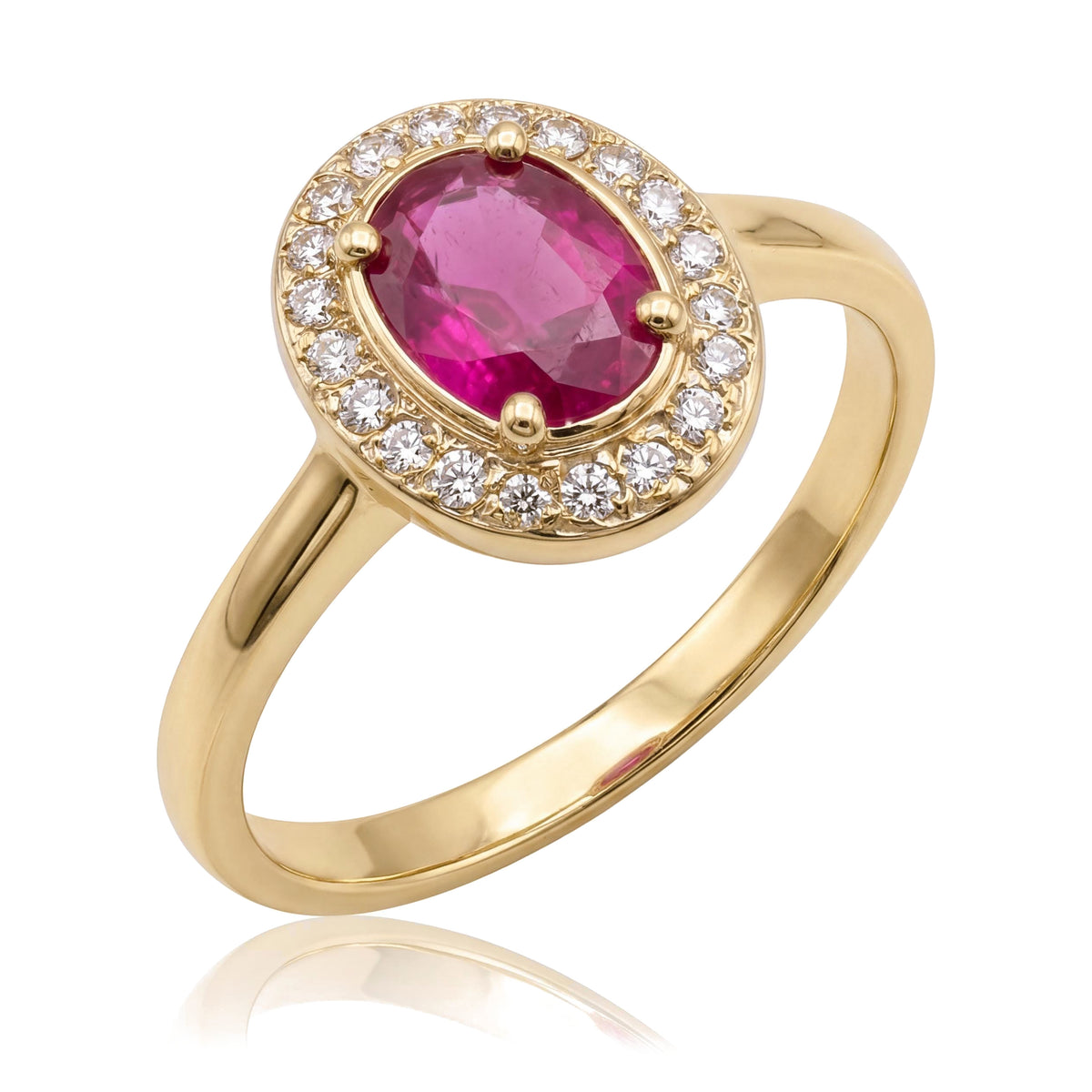 14K yellow gold simulated ruby ring, oval pink-red stone in a halo of small clear stones, angled on white
