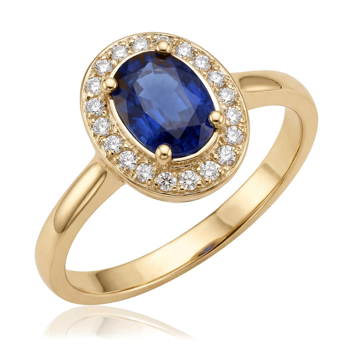 14K yellow gold simulated sapphire ring, oval blue stone in a halo of small clear stones, angled on white